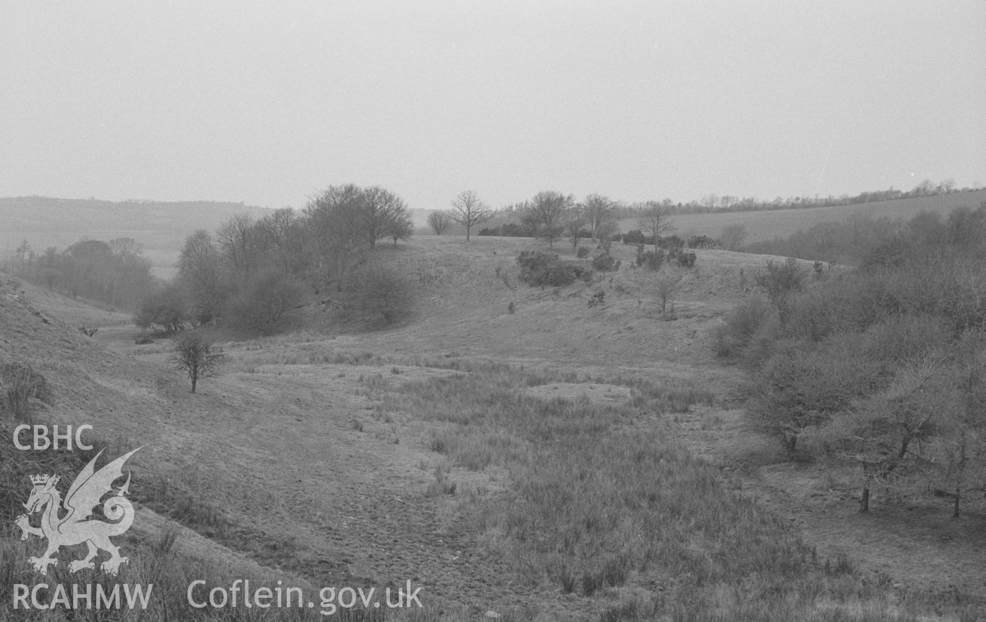 Digital copy of a black and white negative showing Cwm Castell, Mydriolyn, south east of New Quay. Photographed in April 1964 by Arthur O. Chater from Grid Reference SN 4700 5528, looking north north west.