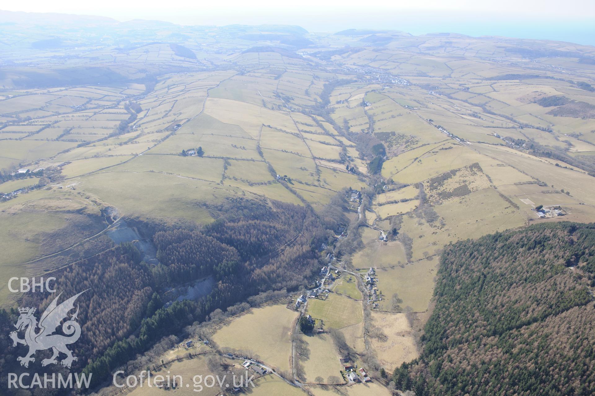 Darren camp hillfort, with Cwmsebon mine in the centre and the village of Pen-bont Rhydybeddau to the east. Oblique aerial photograph taken during the Royal Commission?s programme of archaeological aerial reconnaissance by Toby Driver on 2nd April 2015.