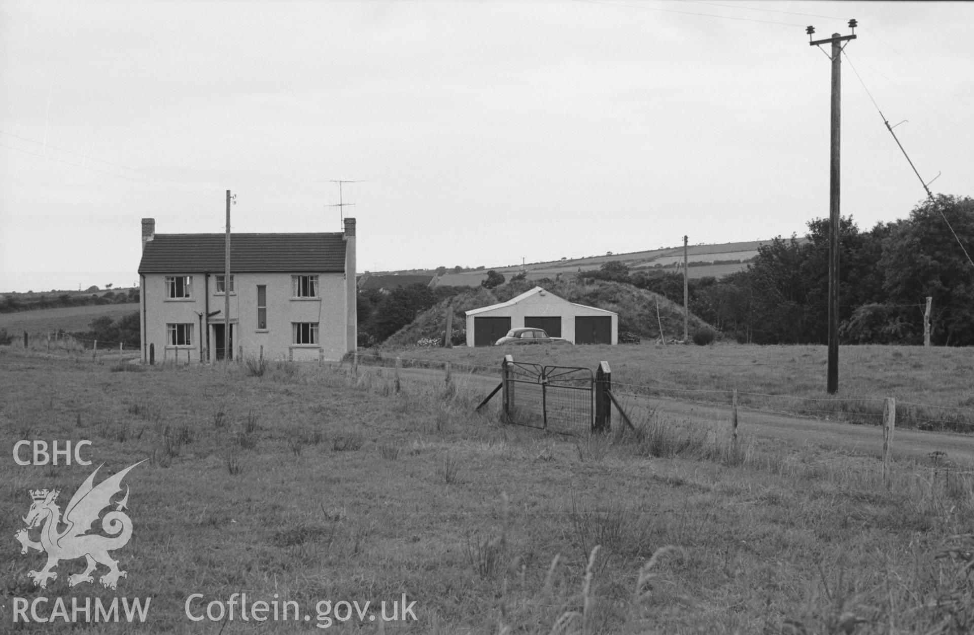 Digital copy of a black and white negative showing the Norman moote of Blaenporth castle (behind garage) and Gaer House. Photographed in August 1963 by Arthur O. Chater from Grid Reference SN 2657 4875, looking north east.