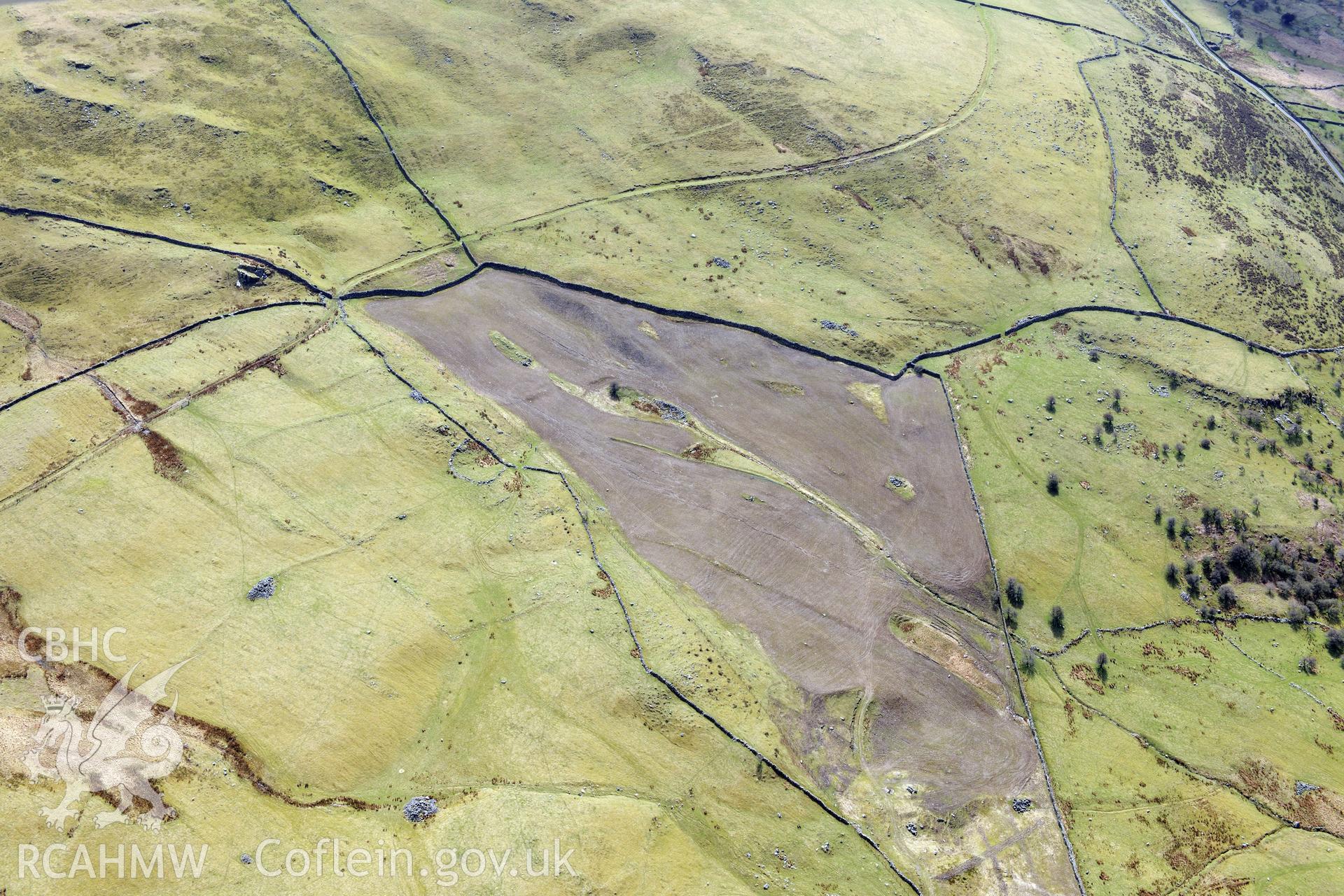 Ffridd Fedw round hut, enclosure, ancient field and kerb cairn, and Tyddyn Sion Wyn ring cairn, Talsarnau, north east of Harlech. Oblique aerial photograph taken during the Royal Commission?s programme of archaeological aerial reconnaissance by Toby Driver on 1st May 2013.