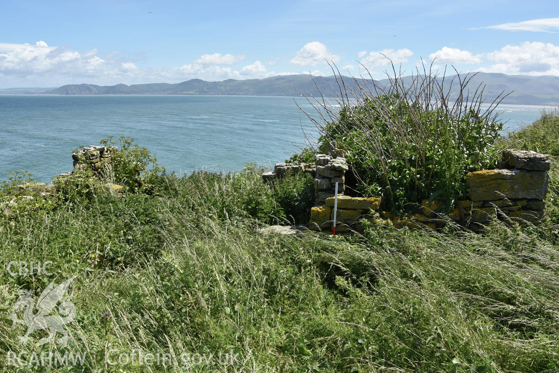 Investigator's photographic survey of the Telegraph Station on Puffin Island or Ynys Seiriol for the CHERISH Project. View of low stone structure set 10m away to the north-east of the main telegraph station. ? Crown: CHERISH PROJECT 2018. Produced with EU funds through the Ireland Wales Co-operation Programme 2014-2020. All material made freely available through the Open Government Licence.