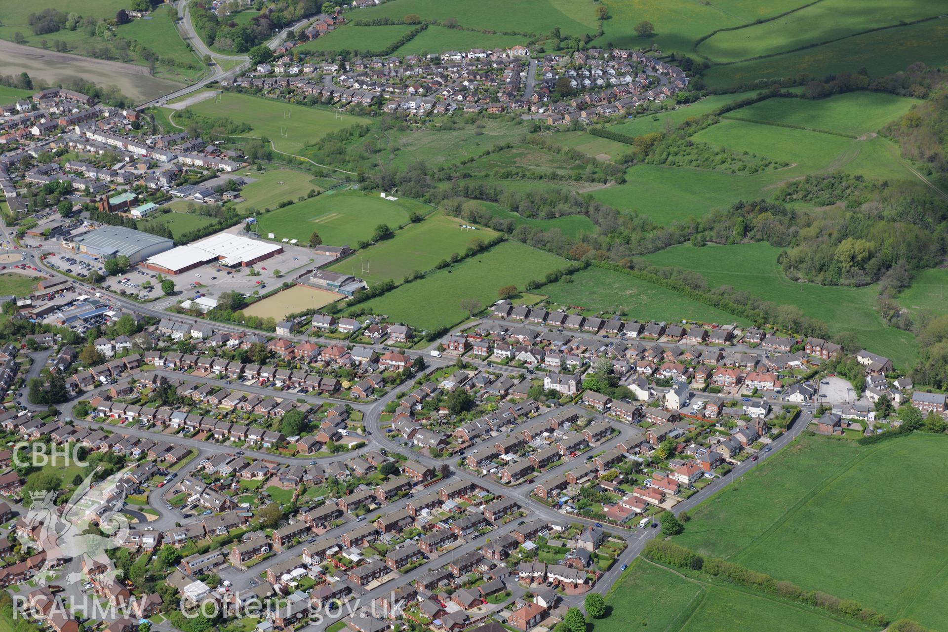 Bryn-yr-Ellyllon Tumulus (findspot of Mold gold cape) and the village of Leadmill, Mold. Oblique aerial photograph taken during the Royal Commission?s programme of archaeological aerial reconnaissance by Toby Driver on 22nd May 2013.