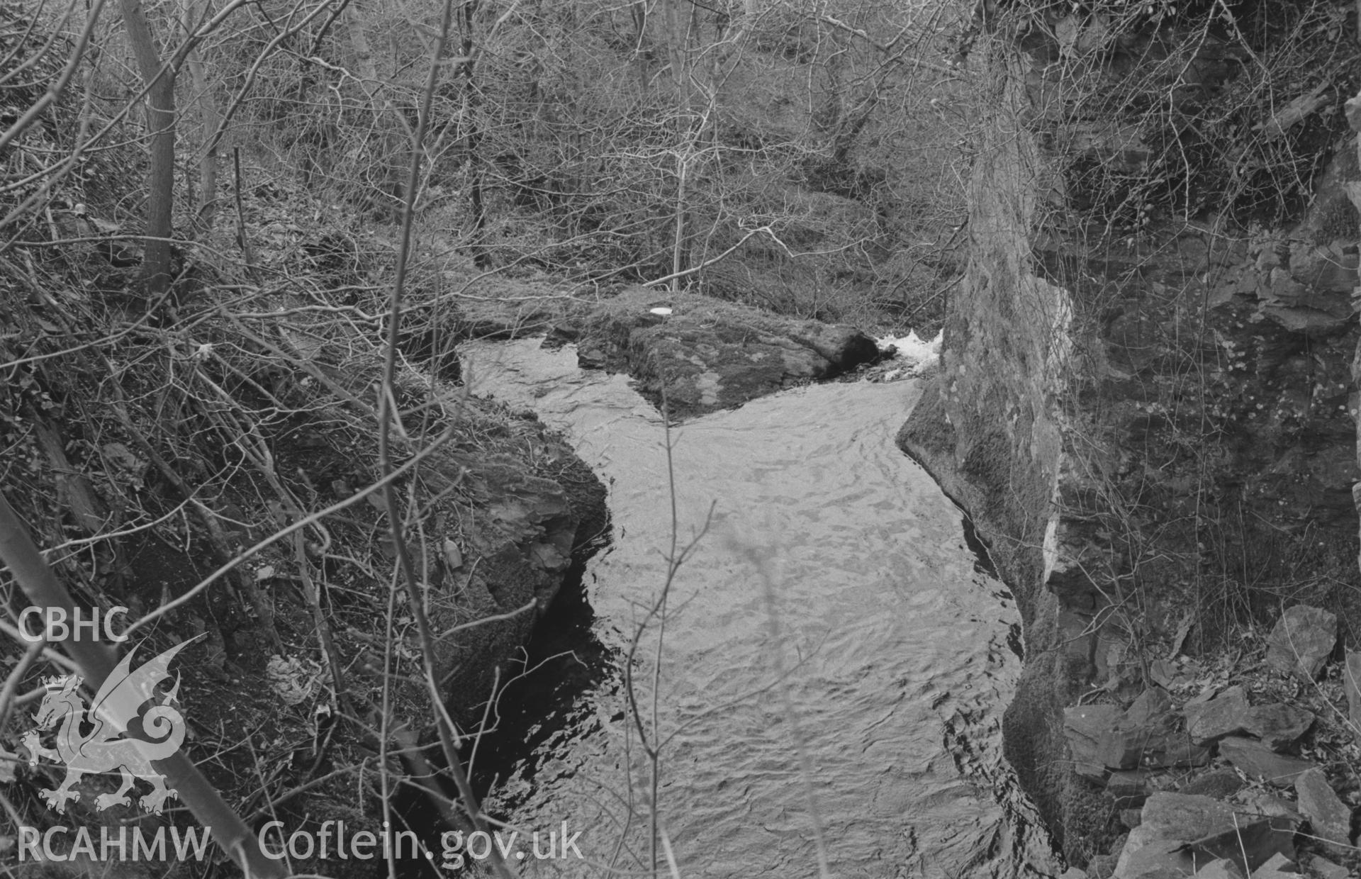 Digital copy of black & white negative showing the Sychnant at brink of Caradog Falls, seen from side of road in village (Grid Ref SN 6928 6951); branch to left leads to millpond by halt. Photographed by Arthur Chater, April 1964, looking west north west.