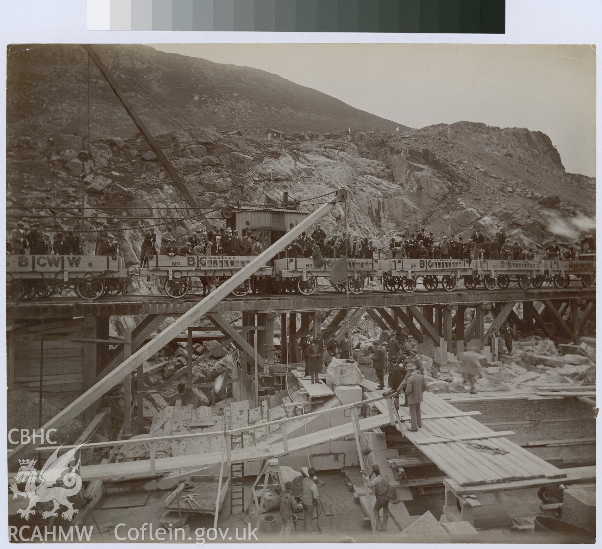 Digital copy of an albumen print from Edward Hubbard Collection showing trucks carrying visitors through the dam site under construction.