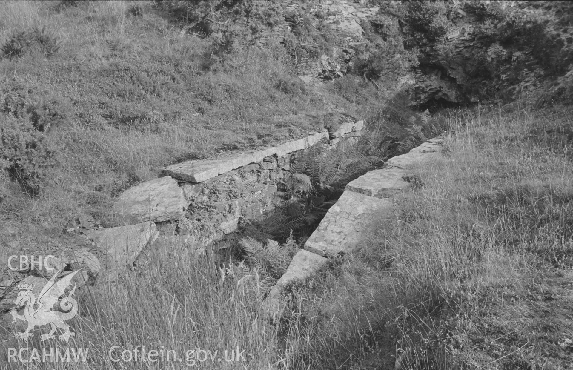 Digital copy of a black and white negative showing platform like structure, near filled with water, at the upper terminus of the tramway at Bryndyfi Mine. Photographed by Arthur O. Chater in August 1966 looking east from Grid Reference SN 687 938.