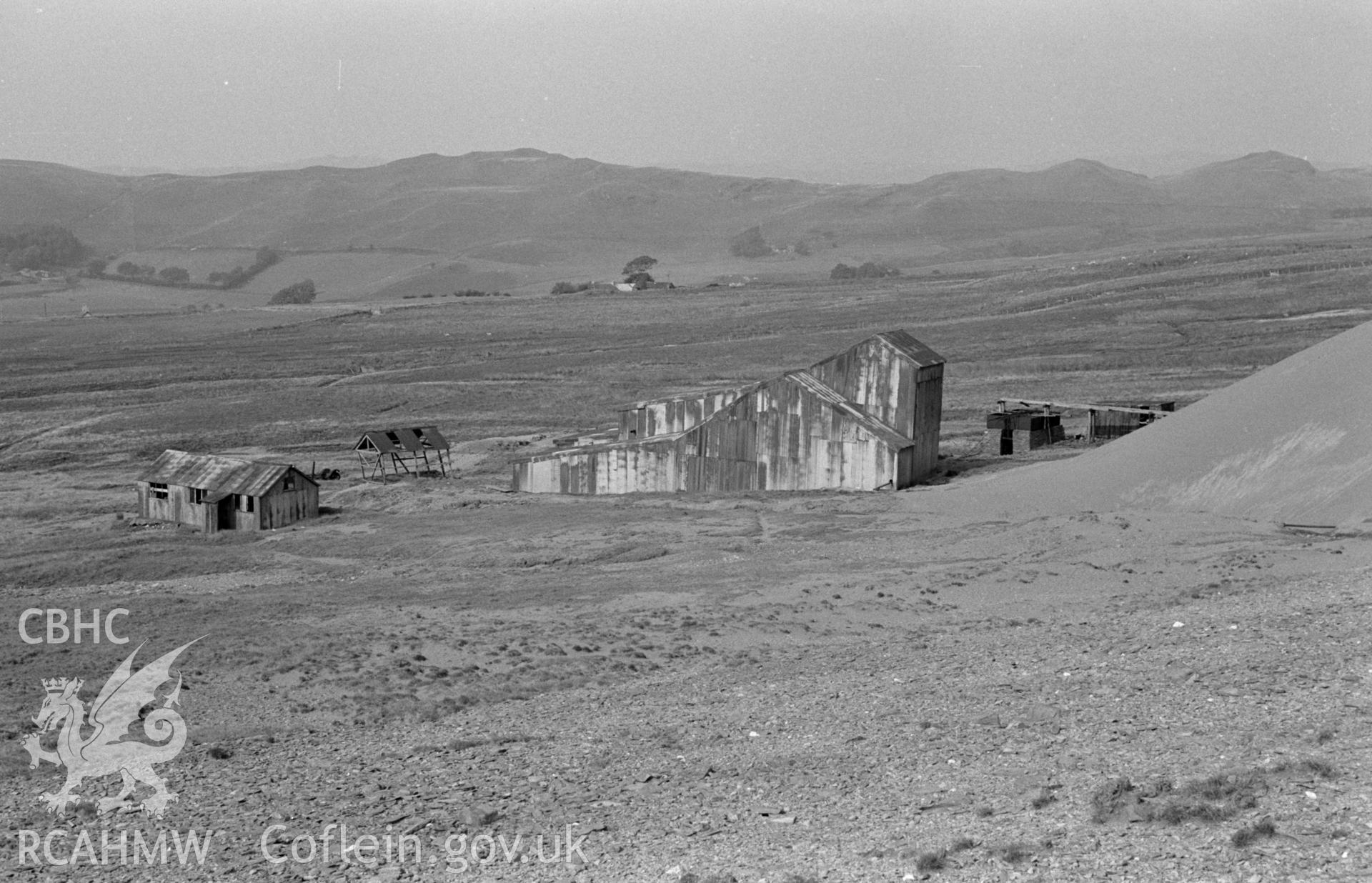 Digital copy of black & white negative showing corrugated iron sheds of Elenith Mining Co. on the lower part of Esgair Mwyn Mine, Ystrad Fflur. Gwar-Ffordd beyond Photographed by Arthur O. Chater, 28 August 1966, looking north north west from SN 755 692.