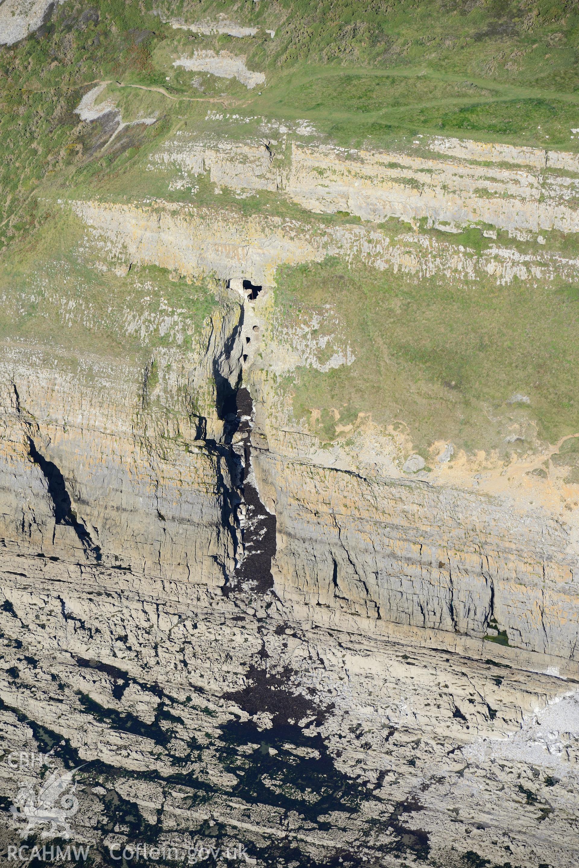 Culver Hole dovecote on the cliffs above Port Eynon Bay, on the southern edge of the Gower Peninsula. Oblique aerial photograph taken during the Royal Commission's programme of archaeological aerial reconnaissance by Toby Driver on 30th September 2015.