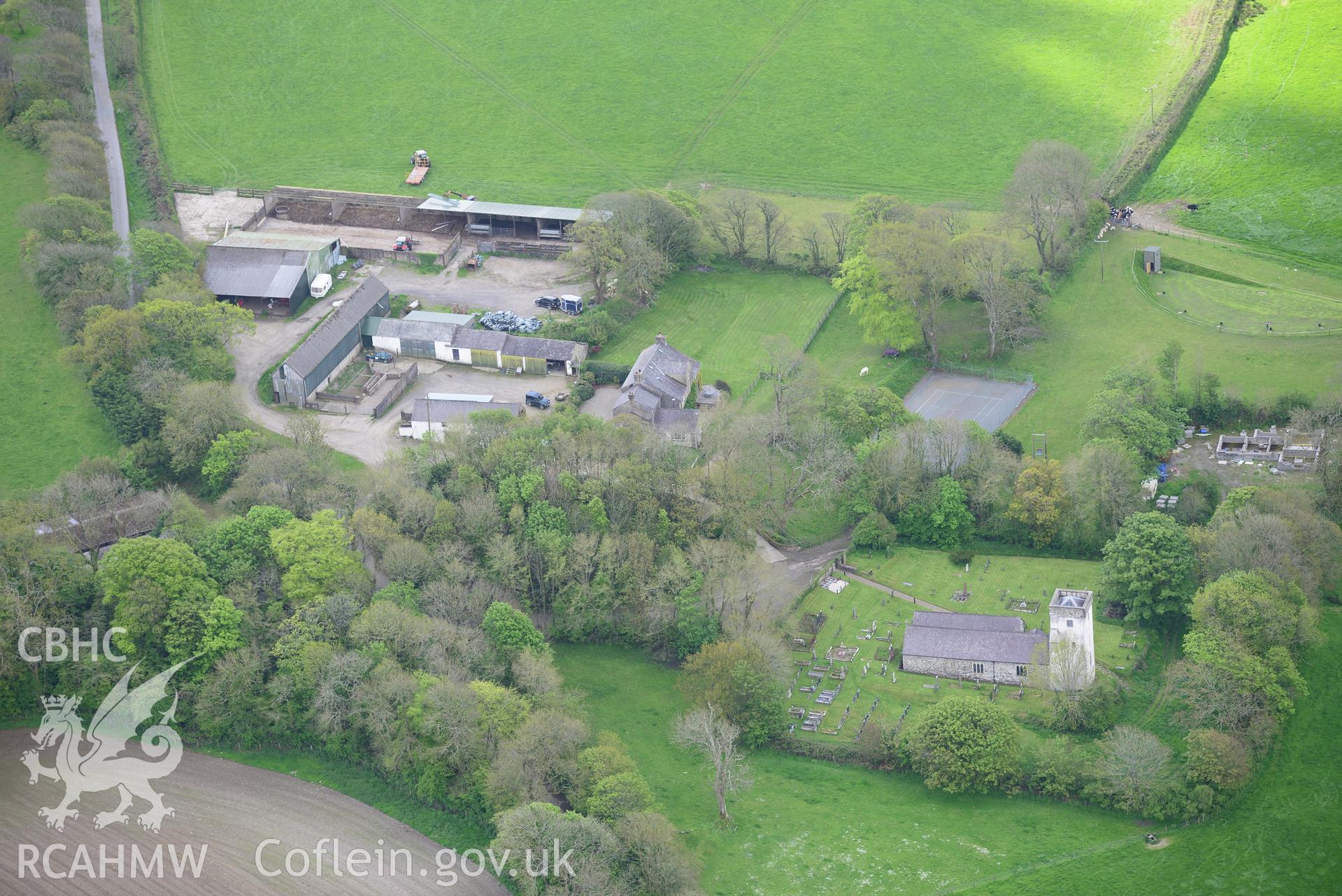 St. Michael's Church and Rudbaxton Mount (beneath the trees between the farm and the church), Rudbaxton. Oblique aerial photograph taken during the Royal Commission's programme of archaeological aerial reconnaissance by Toby Driver on 13th May 2015.