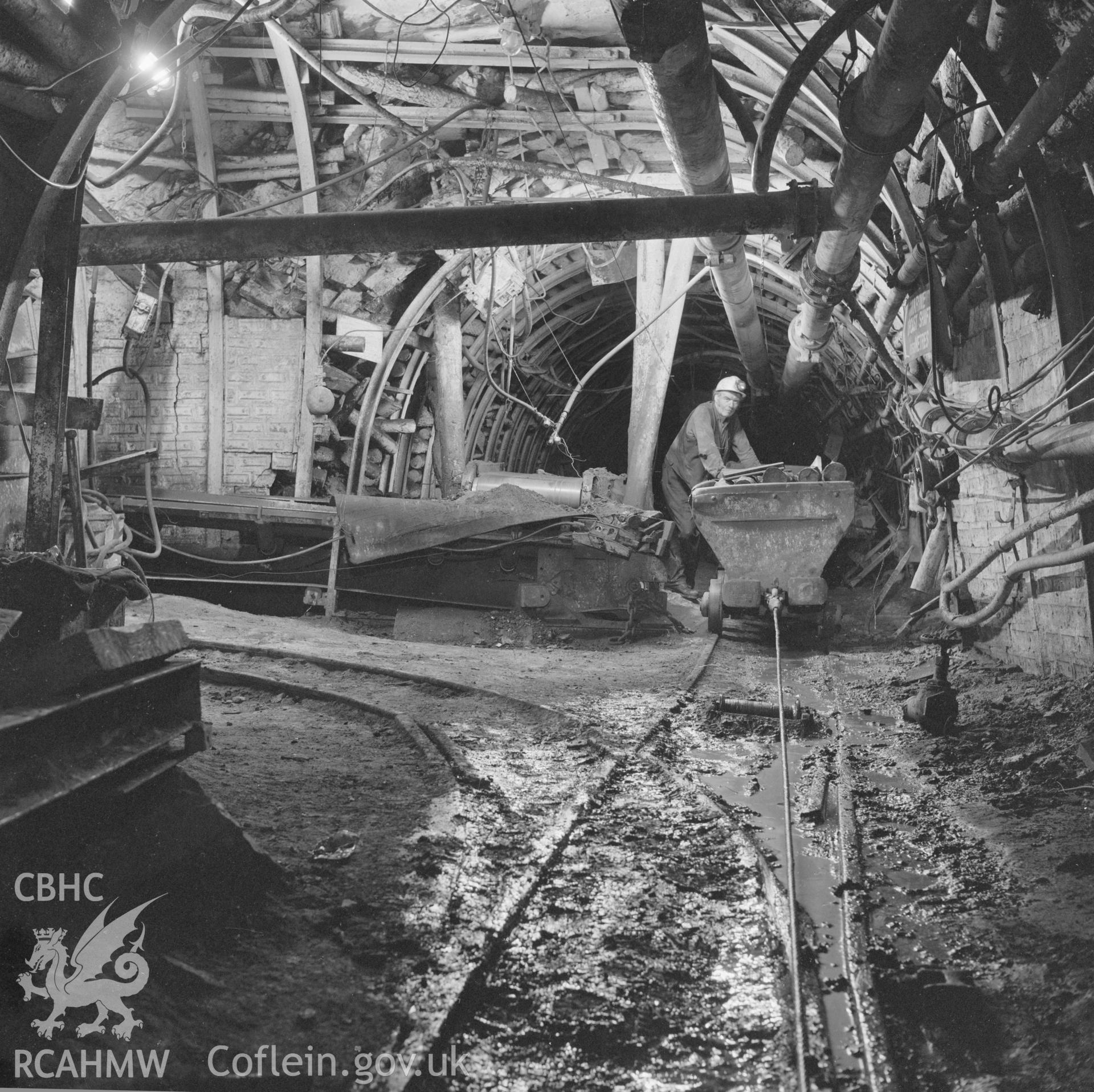 Digital copy of an acetate negative showing transfer point attendant with tram of supplies on haulage system at Marine Colliery, from the John Cornwell Collection.