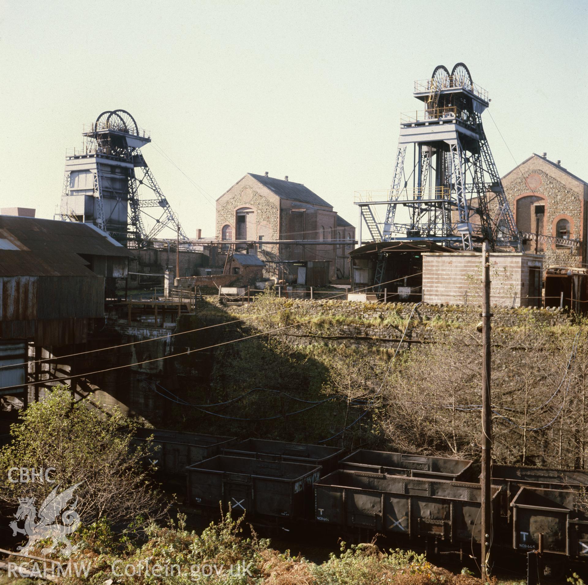 Digital copy of an acetate negative showing surface buildings with pit wheels at St John's Colliery, Maesteg dated 1984, from the John Cornwell Collection.