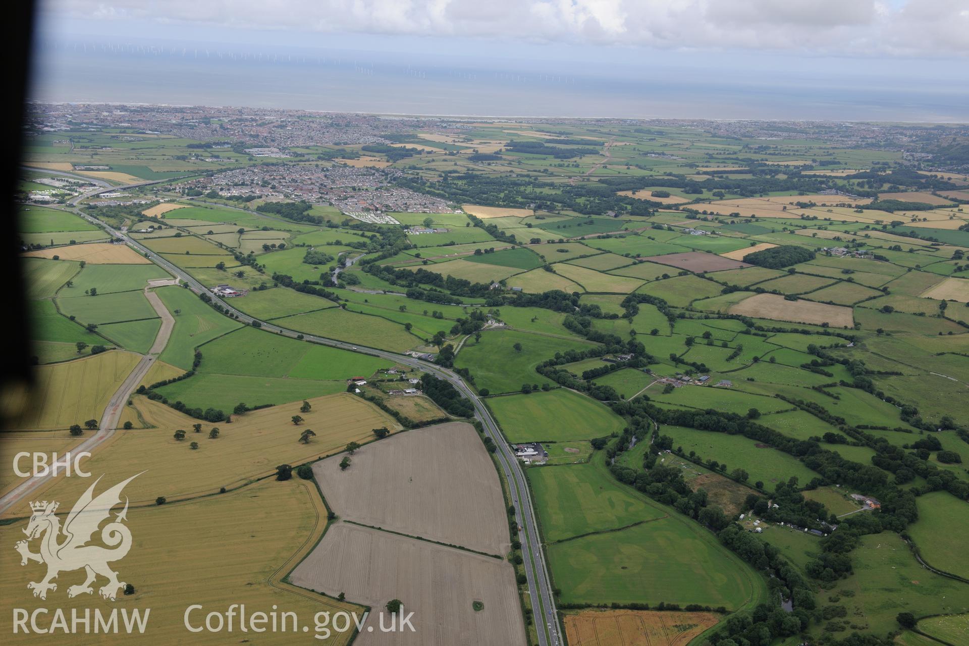 Glyn Derw early field system, Bodelwyddan, with Rhuddlan and Rhyl in the distance. Oblique aerial photograph taken during the Royal Commission's programme of archaeological aerial reconnaissance by Toby Driver on 30th July 2015.