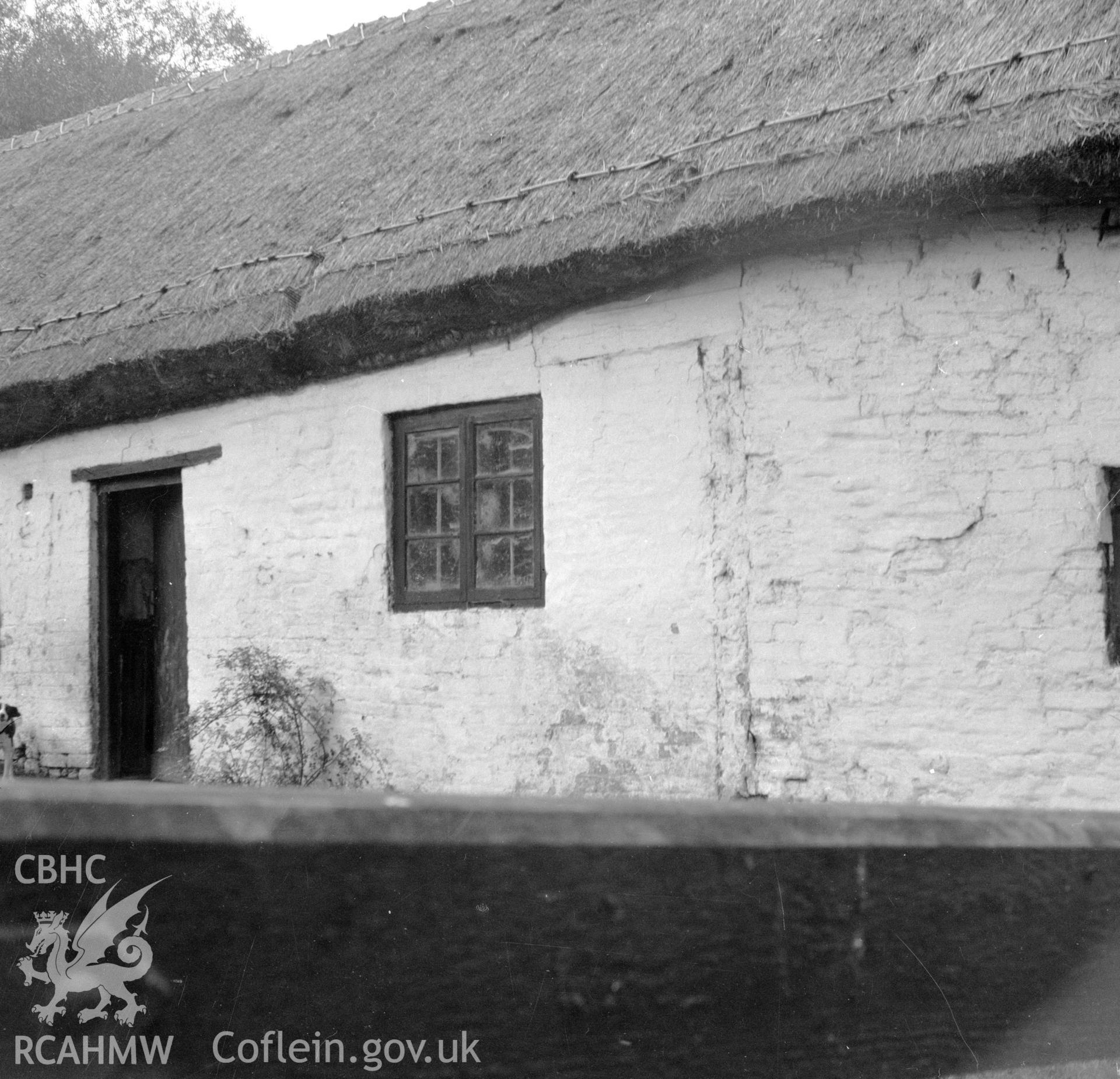 Digital copy of a nitrate negative showing an exterior view of a cruck house at Northop, Flintshire.