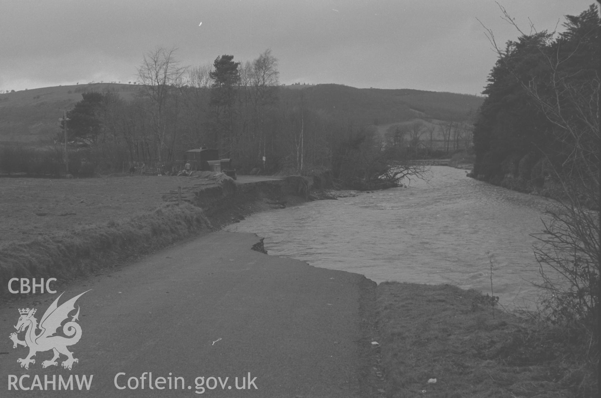 Digital copy of a black and white negative showing damage to the Llanilar road cause by the floods of 12-13th December 1964. Photographed by Arthur O. Chater in December 1964 from Grid Reference SN 6600 7320, looking north.