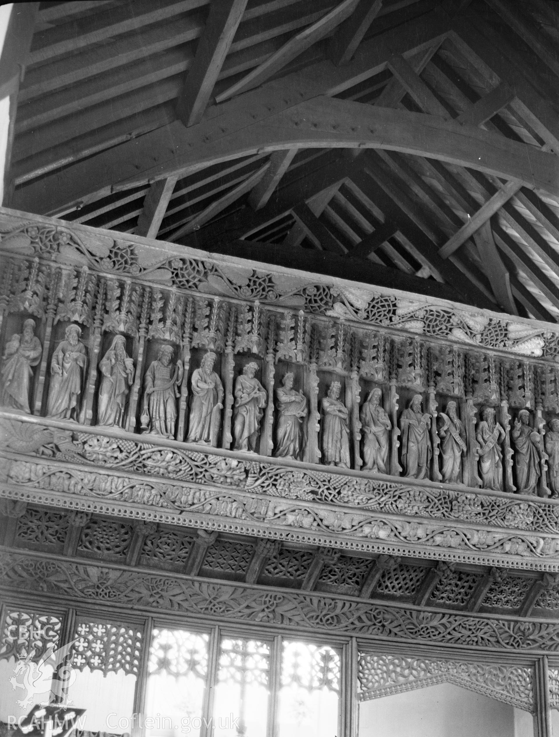 Digital copy of a nitrate negative showing interior view of the screen, showing details of carved figures, St Anno's Church, Llananno. From the National Building Record Postcard Collection.