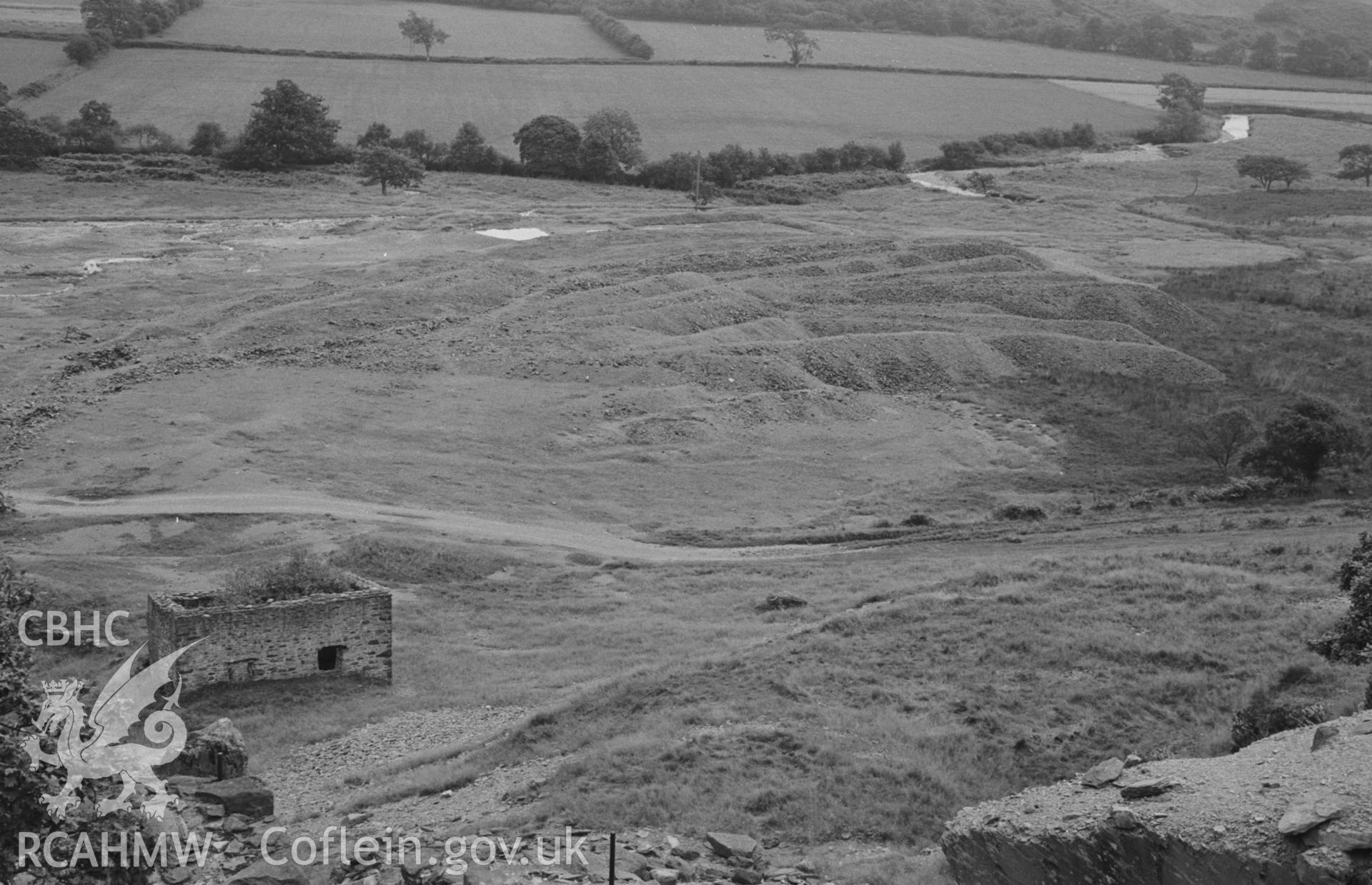 Digital copy of a black and white negative showing the spoil tips of Abbey Consols mine, with the Teifi beyond. Photographed by Arthur O. Chater on 25th August 1967, looking south west from Grid Reference SN 743 662.