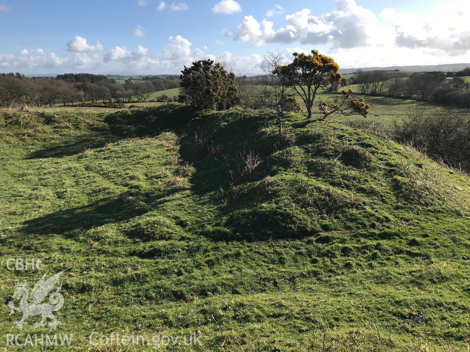 Colour photograph of view of the castle earthworks at Caer Penrhos, taken by Paul R. Davis on 24th March 2019.