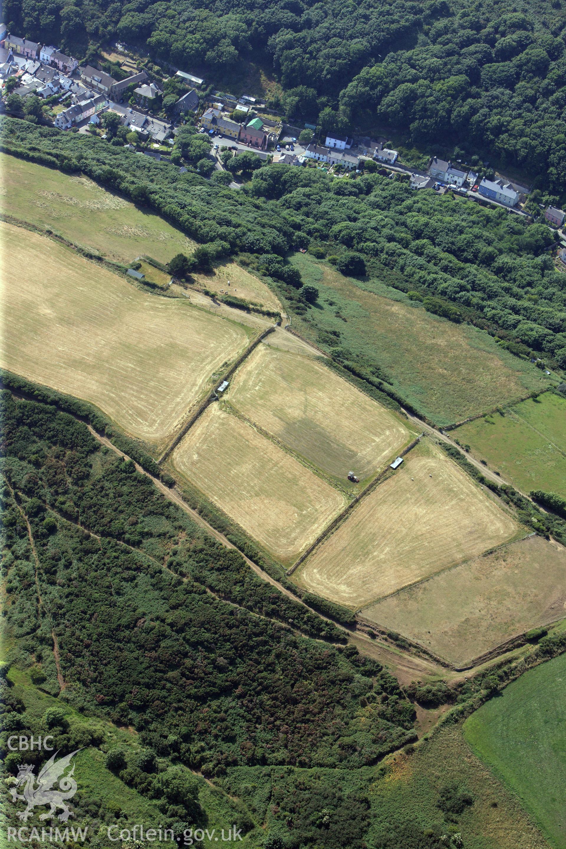 Defended enclosure and the village of Solva. Oblique aerial photograph taken during the Royal Commission?s programme of archaeological aerial reconnaissance by Toby Driver on 16th July 2013.