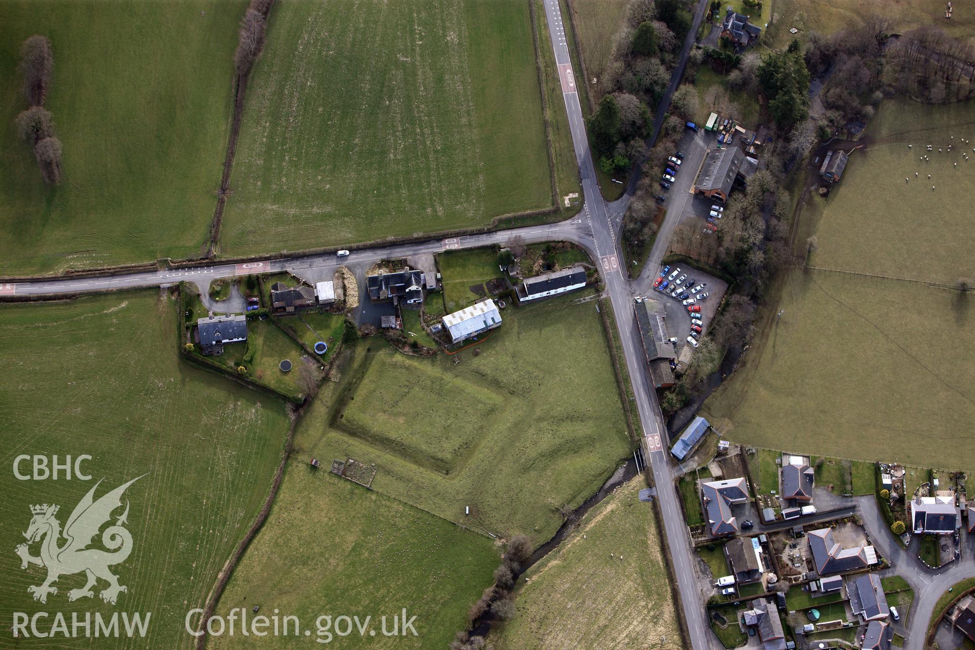 Tregynon moat, with Concrete Cottage and the Tithe Barn cottages above, north west of Newtown. Oblique aerial photograph taken during the Royal Commission?s programme of archaeological aerial reconnaissance by Toby Driver on 28th February 2013.