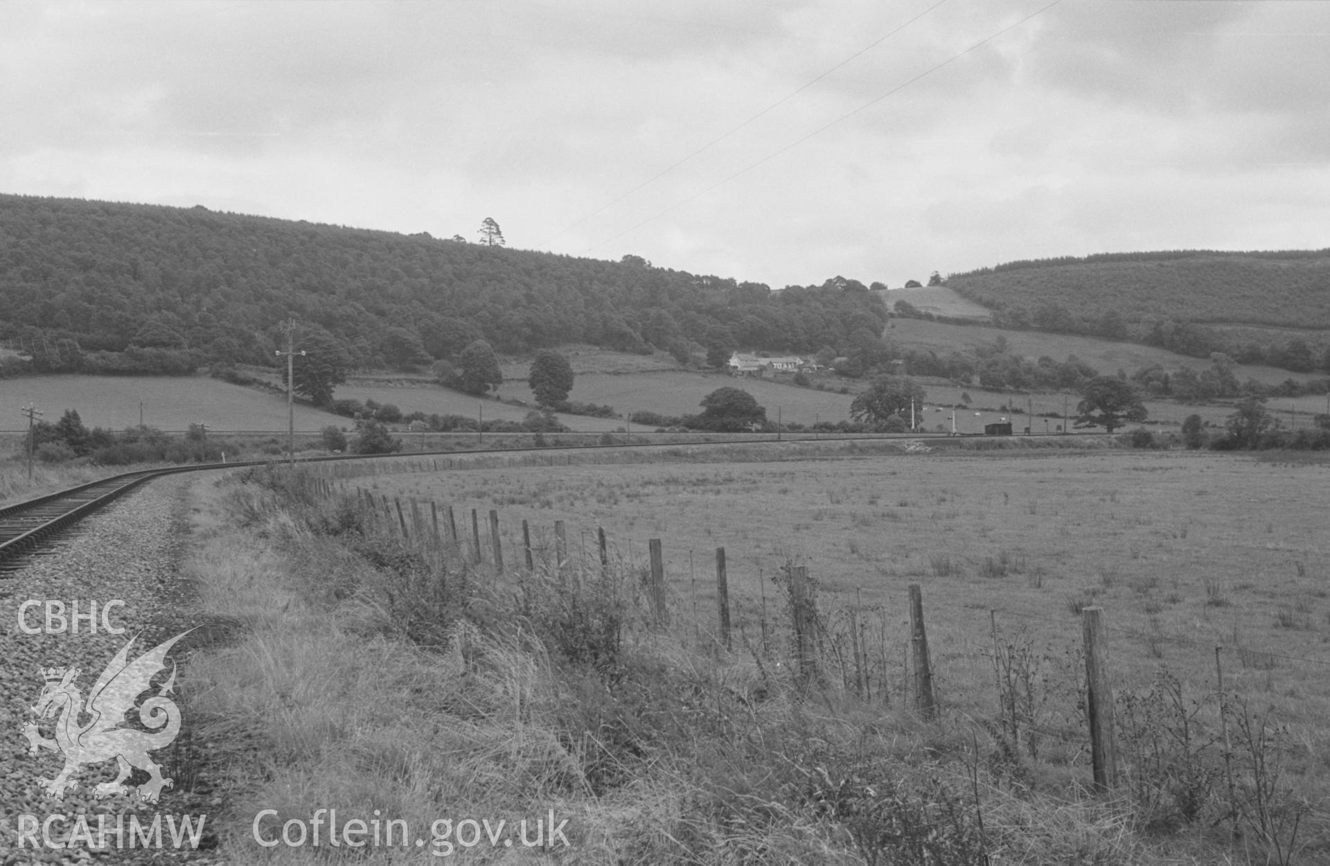 Digital copy of black & white negative showing view along Lampeter, Aberayron & New Quay Light Railway to its junction with the Lampeter-Aberystwyth line at Silian. Photographed by Arthur O. Chater, 4th September 1966 looking south east from SN 585 507.