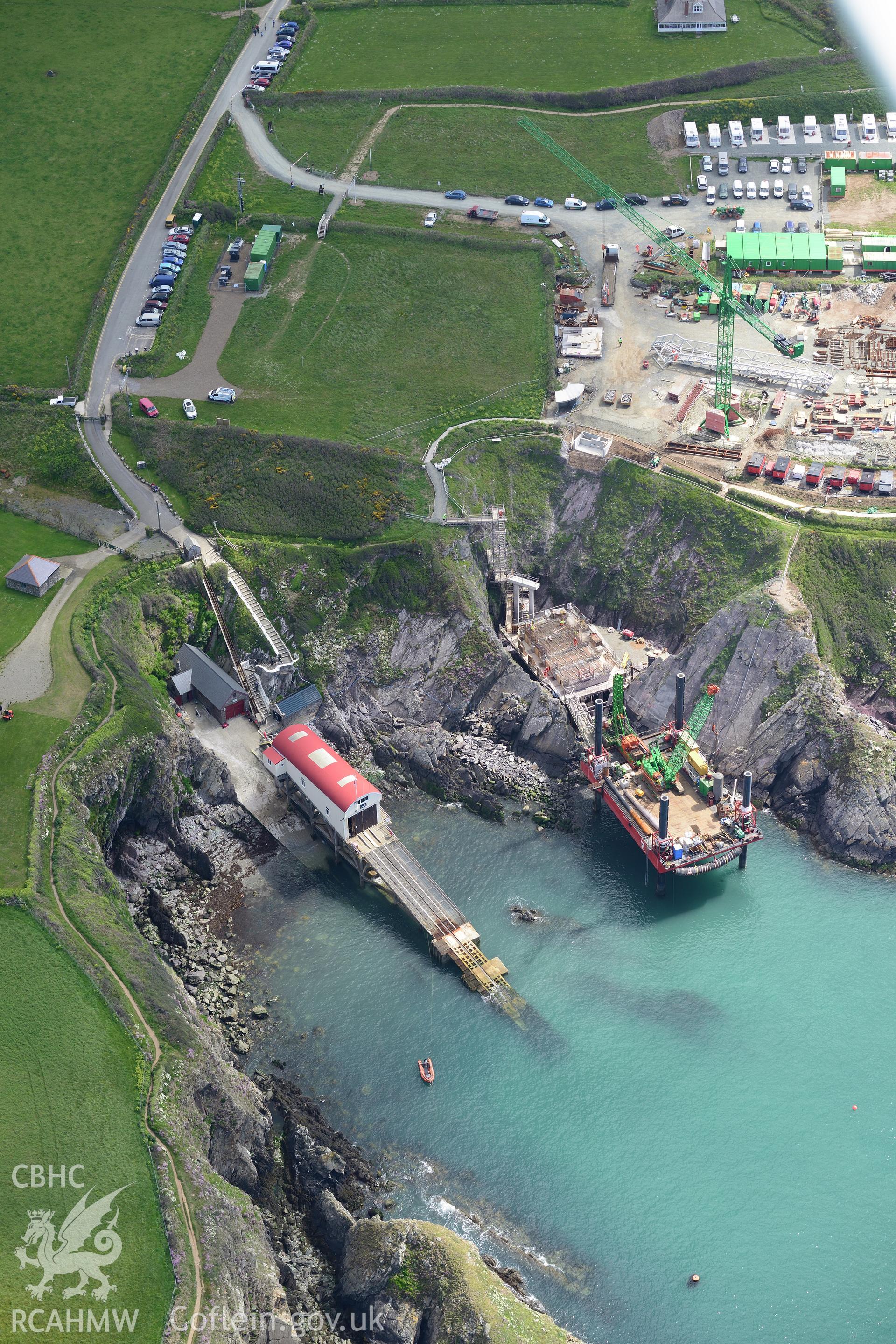 St. David's old lifeboat station with the new station under construction. The floating mooring used by the crew whilst the station was being built is also visible. Oblique aerial photograph taken during the Royal Commission's programme of archaeological aerial reconnaissance by Toby Driver on 13th May 2015.