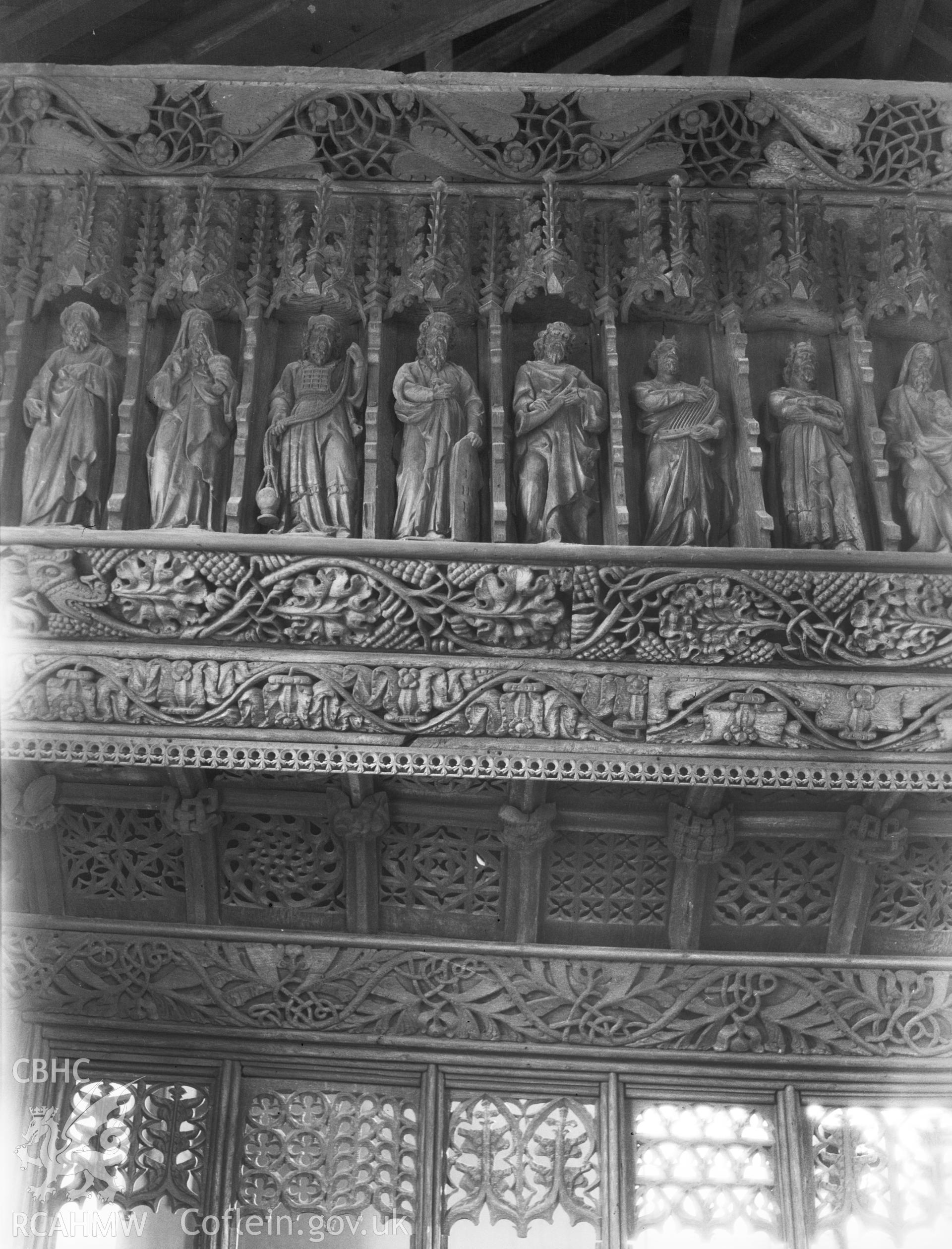 Digital copy of a nitrate negative showing interior view of the screen, showing details of carved figures, St Anno's Church, Llananno.  From the National Building Record Postcard Collection.