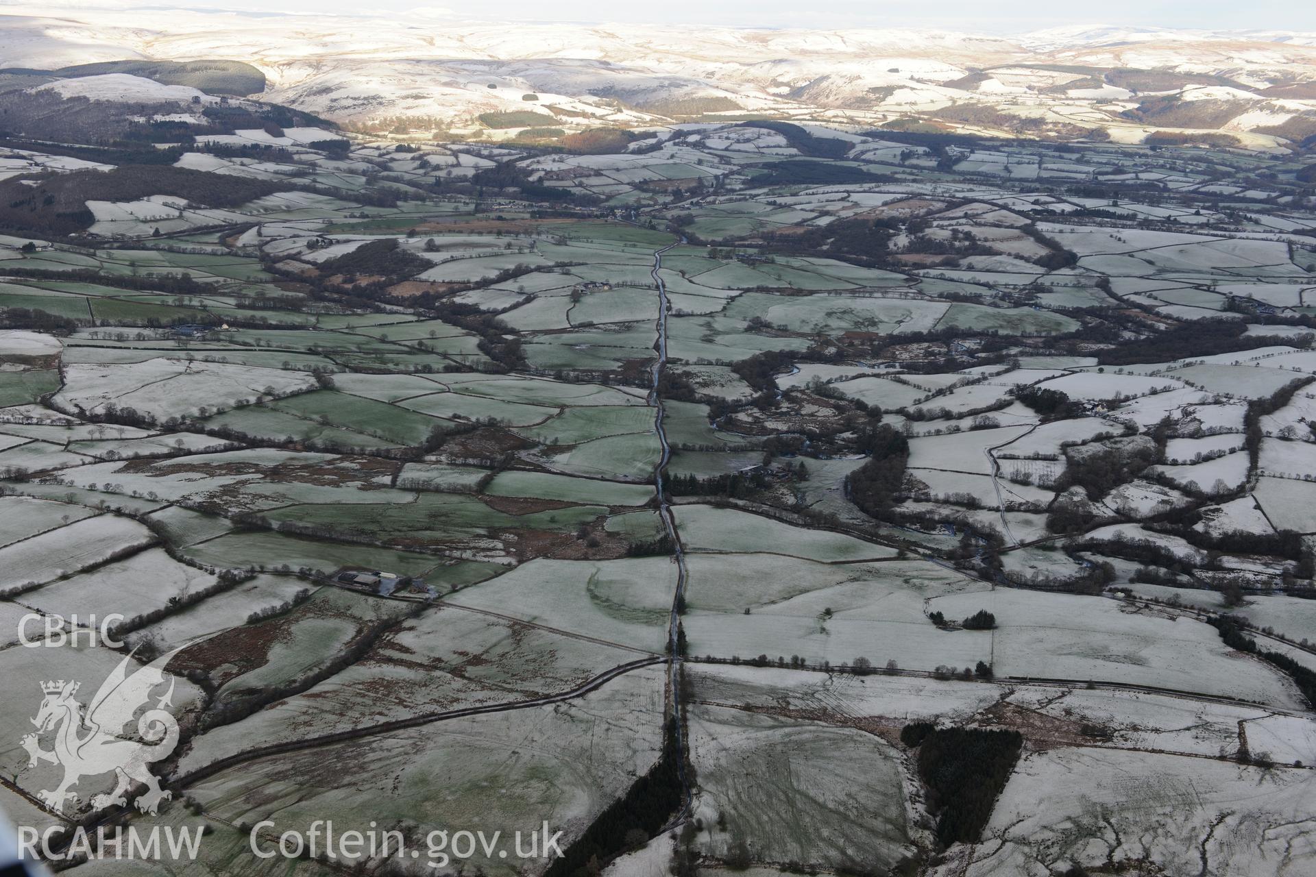 Caerau Roman fort and military settlement, and the Roman road between Beulah and Llandovery (part of RR623). Oblique aerial photograph taken during Royal Commission?s programme of archaeological aerial reconnaissance by Toby Driver on 15th January 2013.