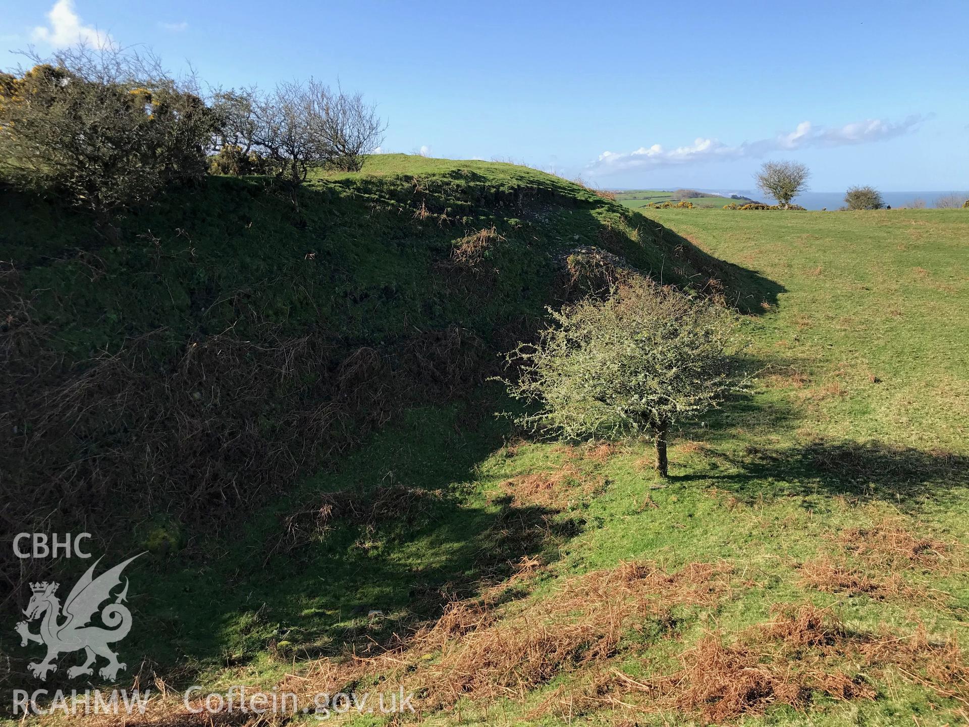 Colour photograph of view of the castle earthworks at Caer Penrhos, taken by Paul R. Davis on 24th March 2019.