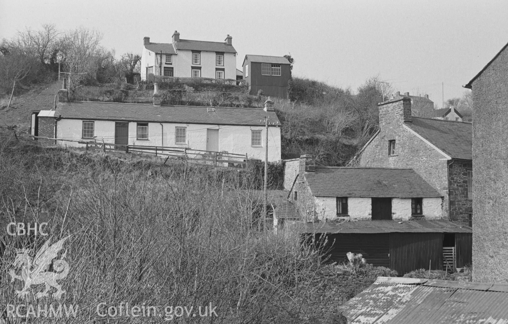 Black and White photograph showing view from the main road of houses on the slope at Llanarth village. Photographed by Arthur Chater in April 1963 from Grid Reference SN 423 575, looking north west.