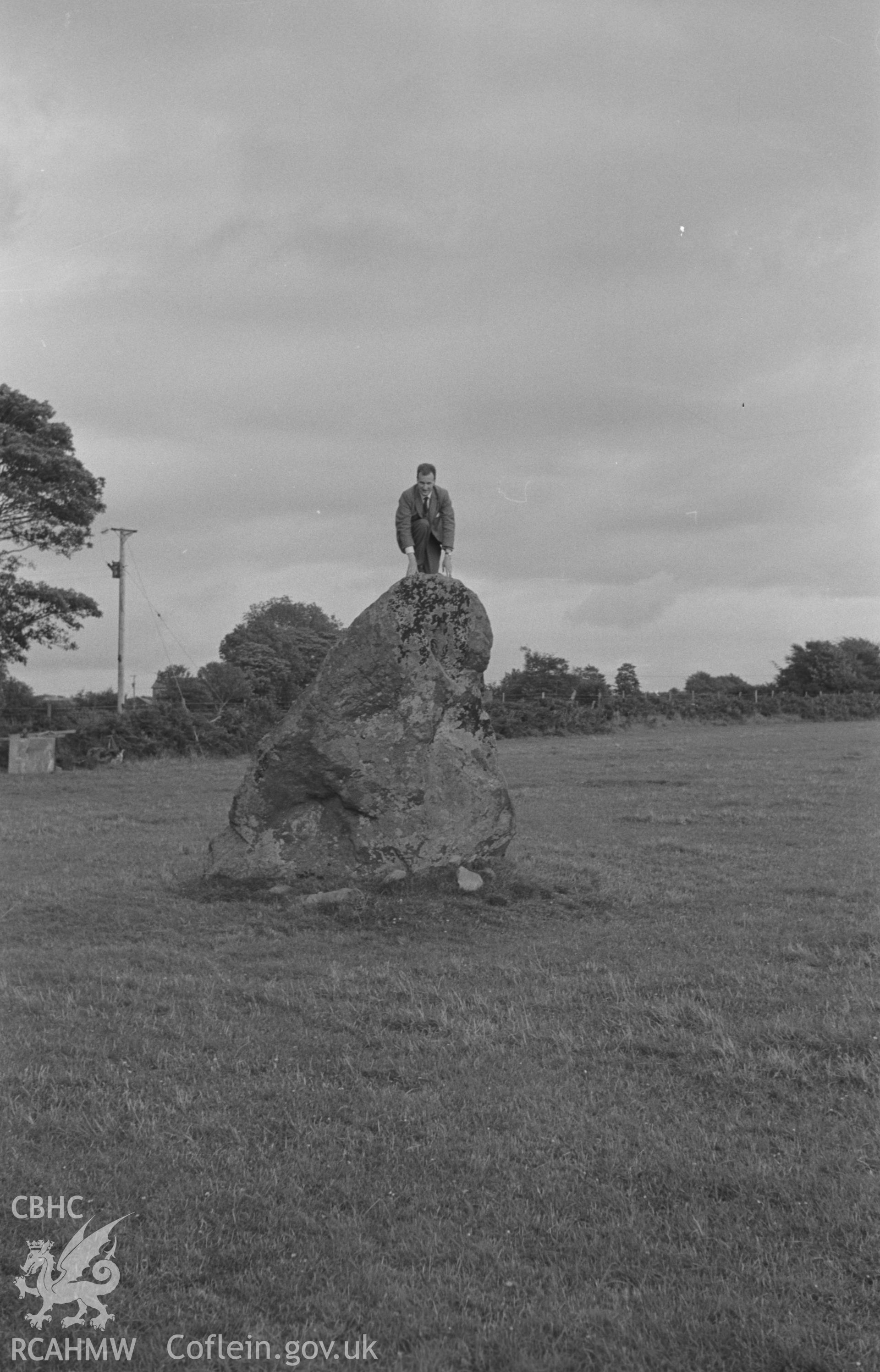 Black and White photograph showing Llech Gron standing stone, Dyffryn Arth with figure. Photographed by Arthur Chater in August 1962 from Grid Reference SN 542 648, looking east.