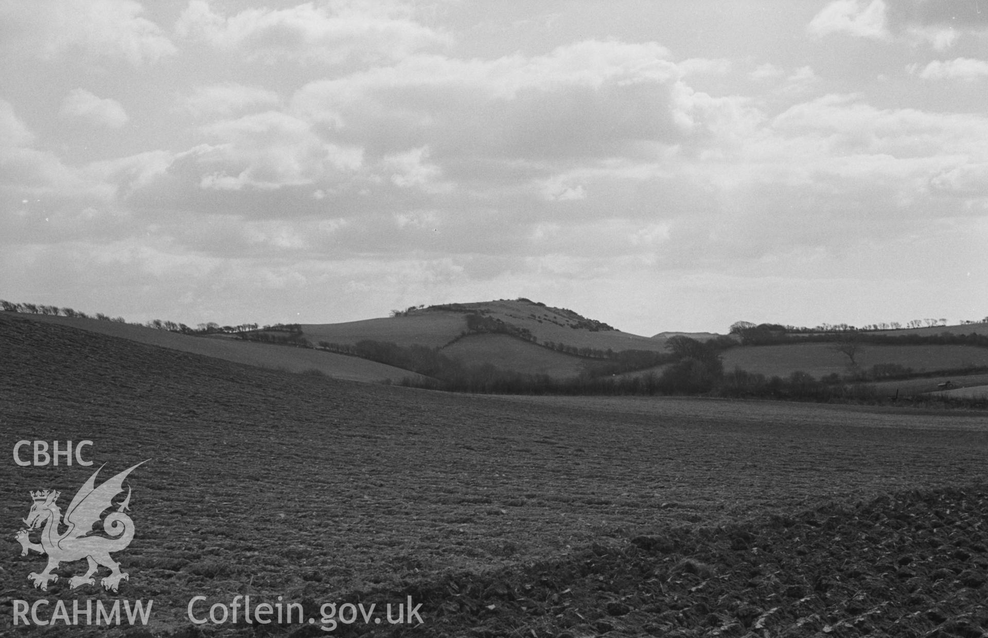 Black and White photograph showing Cae Allt-Goch iron-age camp from the road 500m south south-west of Staylittle, Talybont. Photographed by Arthur Chater in April 1963, from Grid Reference SN 642 891, looking south.