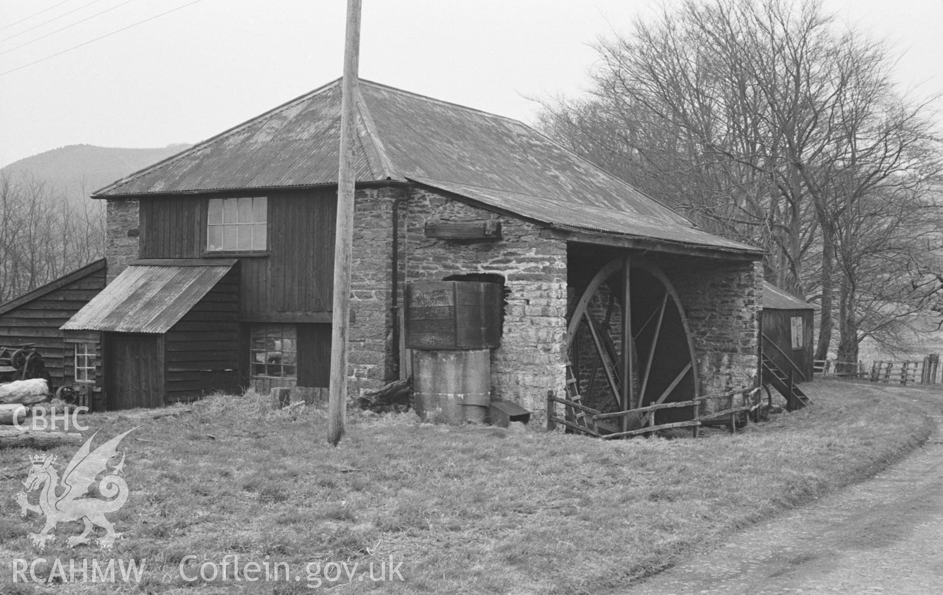 Black and White photograph showing Abermagwr timber mill with undershot waterwheel, situated between the road and the river at Aber-Magwr. Photographed by Arthut Chater in April 1963. Taken from grid ref: SN 6656 7380, looking south west.