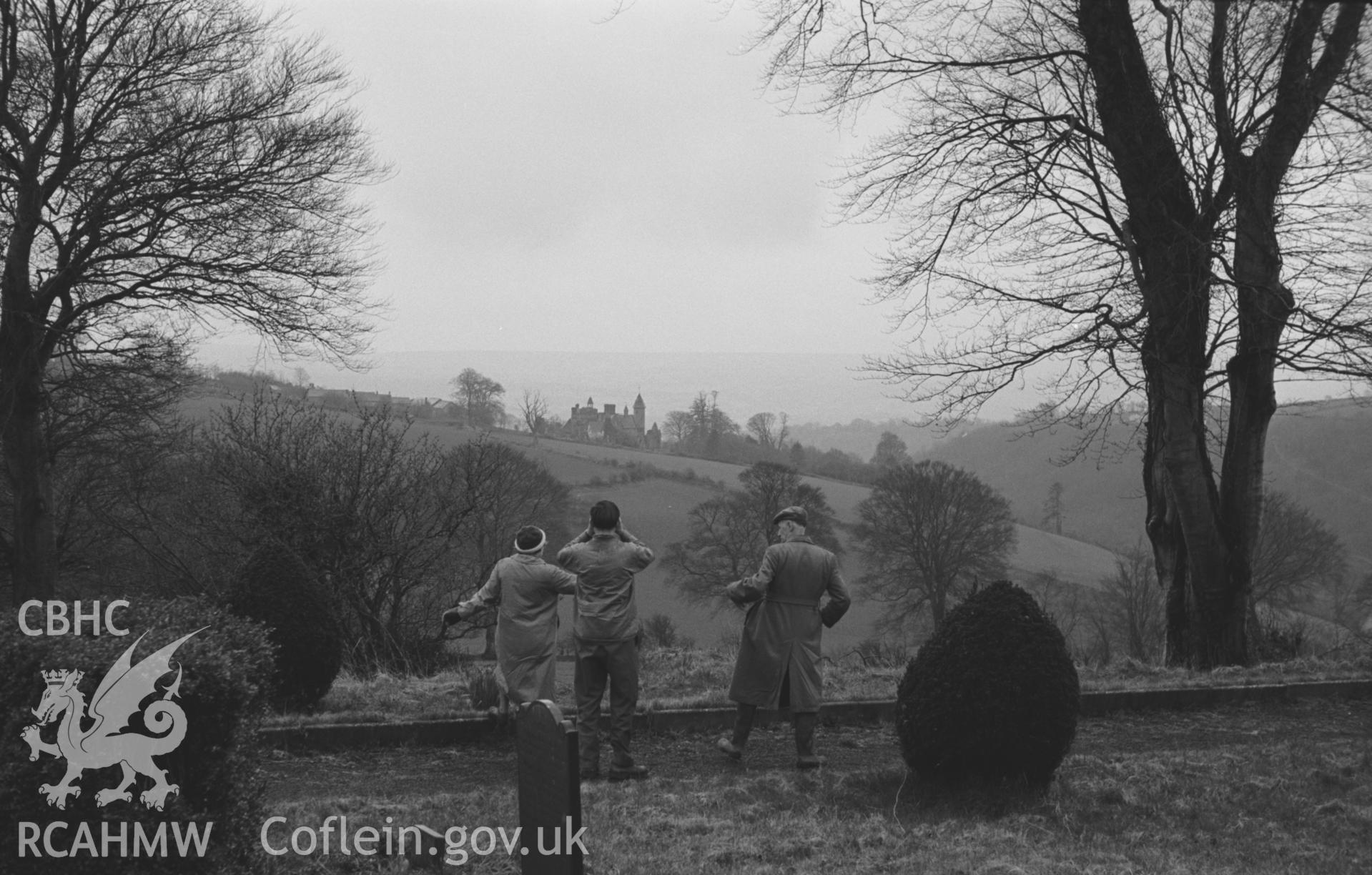 Black and White photograph showing distant view of Bronwydd from Llangynllo churchyard, with three figures. Photographed by Arthur Chater in April 1962, from Grid Reference SN 352 439, looking south.