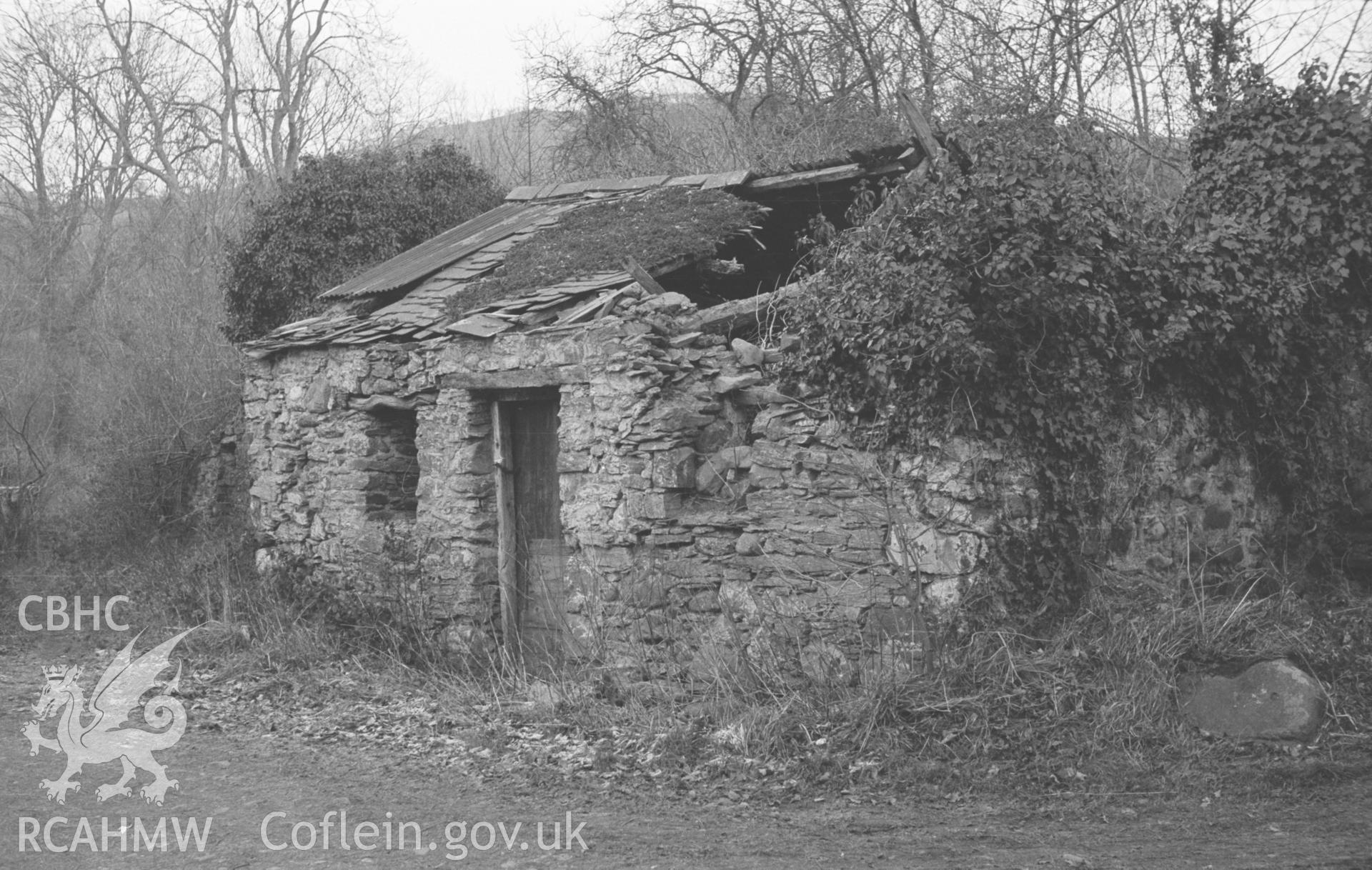 Digital copy of a black and white negative showing ruined smithy 50m east south east of Capel Soar, Tre'r Ddol. Photographed in December 1963 by Arthur O. Chater from Grid Reference SN 6599 9213, looking north east.