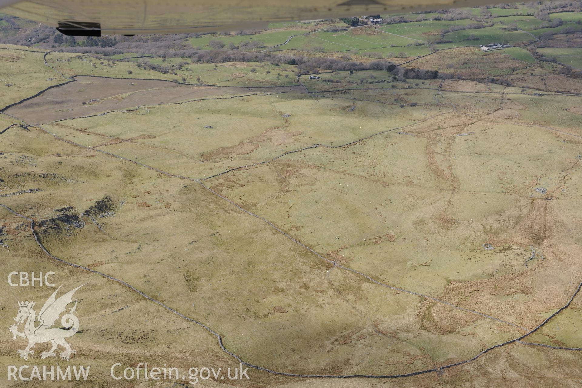 Ffridd Fedw round hut, enclosure, ancient field and kerb cairn, and Tyddyn Sion Wyn ring cairn, Talsarnau, north east of Harlech. Oblique aerial photograph taken during the Royal Commission?s programme of archaeological aerial reconnaissance by Toby Driver on 1st May 2013.