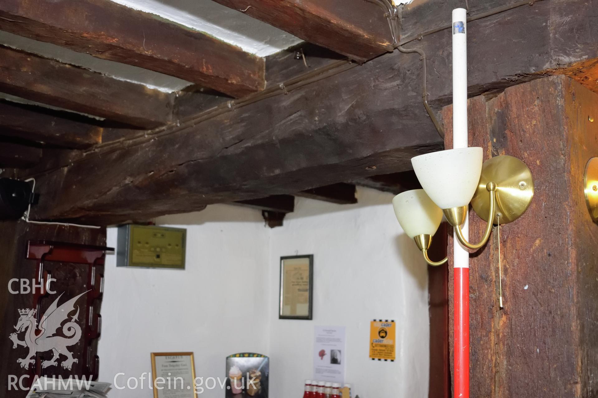 Colour photograph showing view looking south at chamfer and stop on the eastern ceiling beam at Y Sospan, Llys Owain, Dolgellau. Photographed by I. P. Brookes of Engineering Archaeological Services, June 2019.