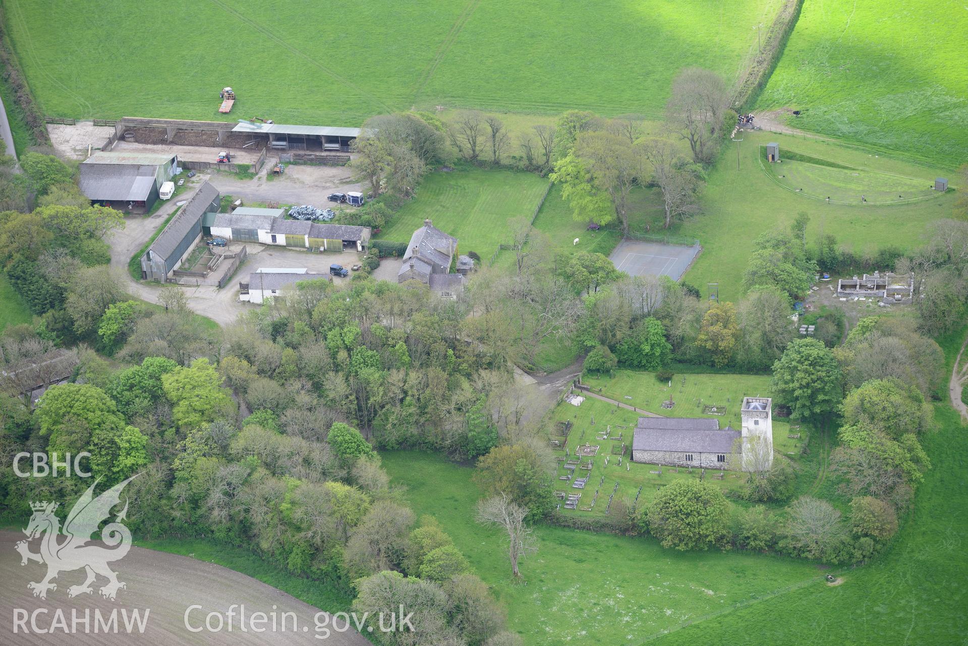 St. Michael's Church and Rudbaxton Mount (beneath the trees between the farm and the church), Rudbaxton. Oblique aerial photograph taken during the Royal Commission's programme of archaeological aerial reconnaissance by Toby Driver on 13th May 2015.