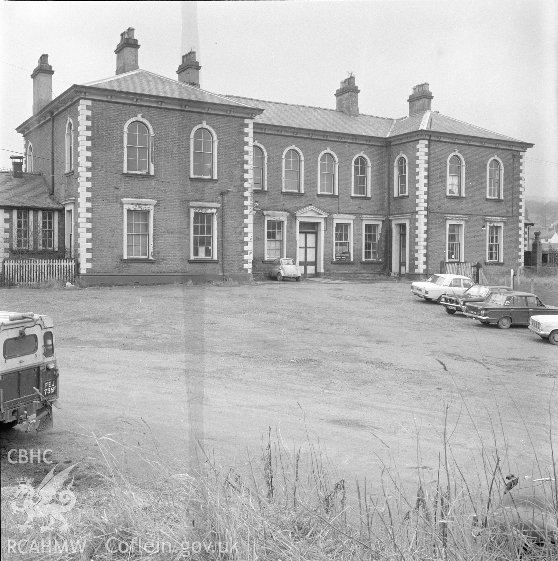 Digital copy of a black and white negative showing the front elevation of Llanidloes Railway Station, taken by Douglas Hague.