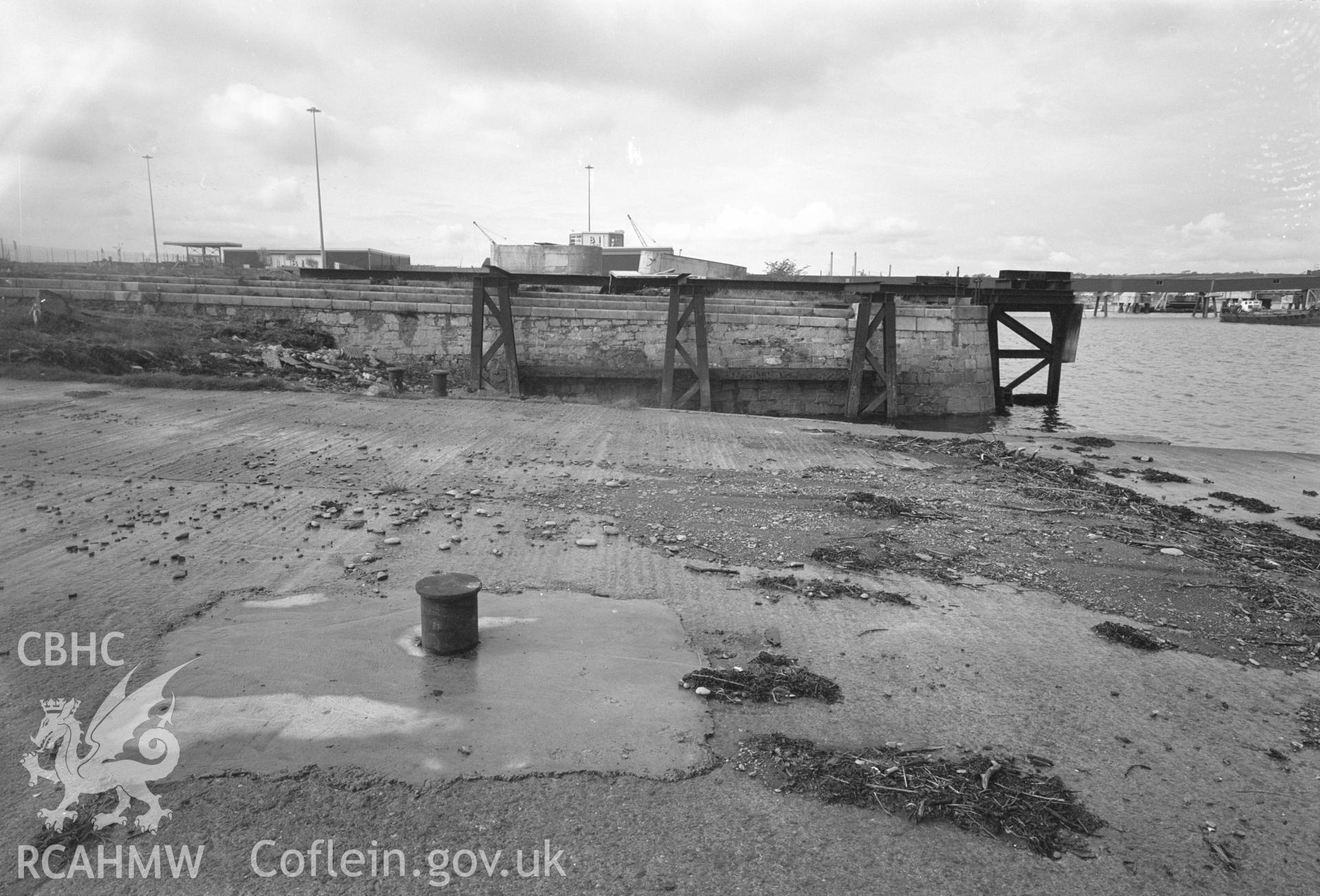 Black and white negative showing Old Royal Dockyard Pembroke - concrete surface of lowered and ramped pier looking NW over ship building slip 10 to pier beyond. taken by RCAHMW.