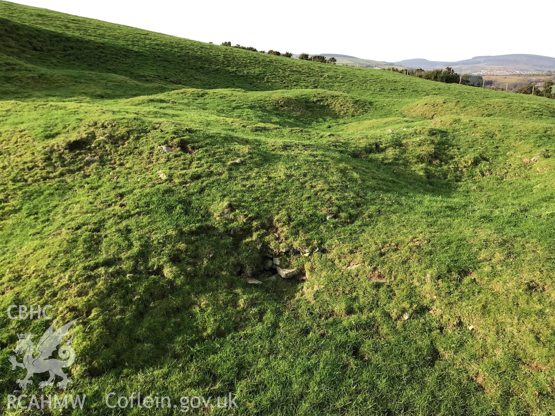 Digital colour photograph showing buried stonework at Nant-yr-Hwyaid house platform, Glyncorrwg, taken by Paul Davis on 5th February 2020.