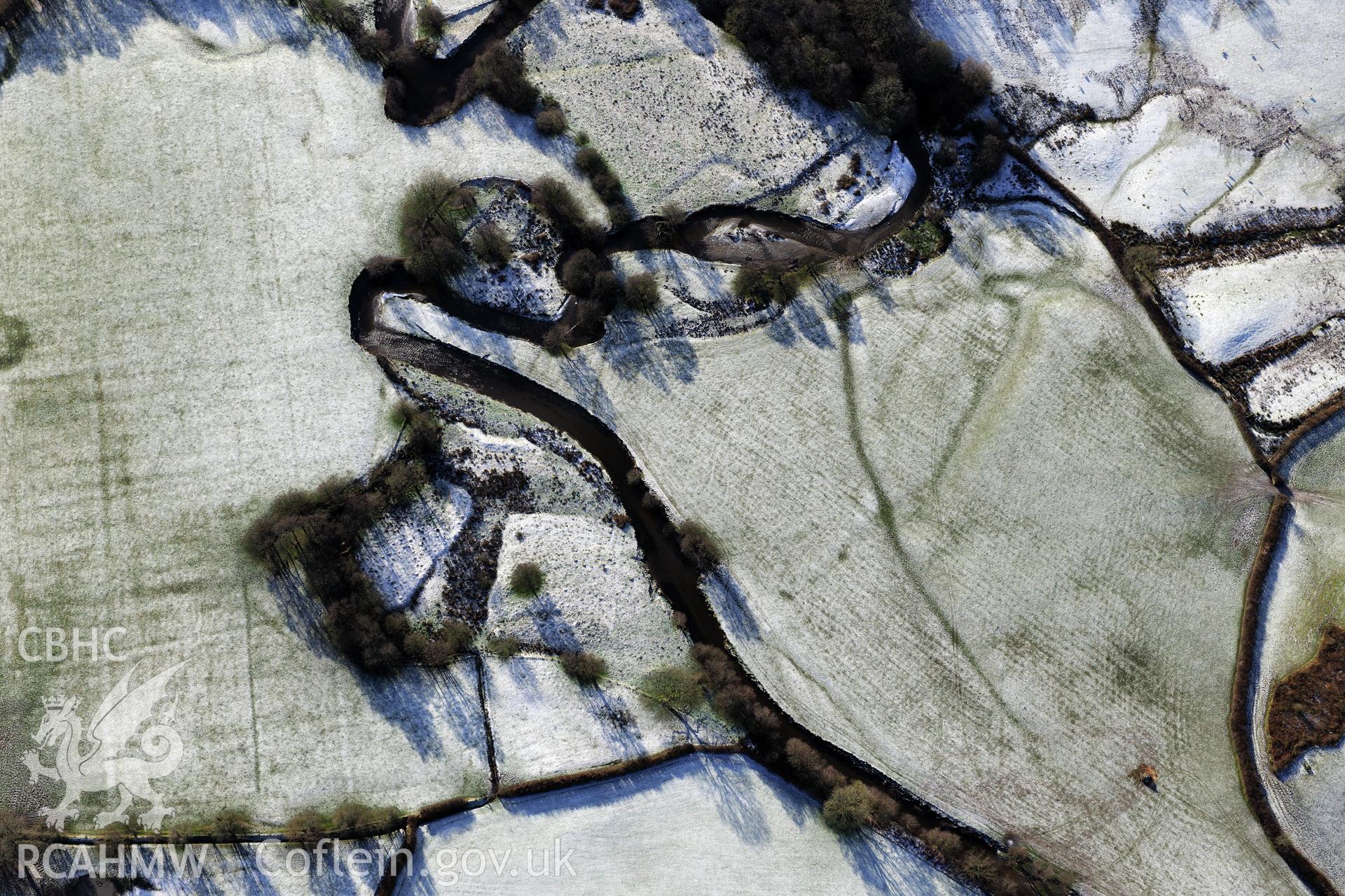 Riverside earthworks to the south-east of Caerau Roman Fort, Beulah, west of Builth Wells. Oblique aerial photograph taken during the Royal Commission?s programme of archaeological aerial reconnaissance by Toby Driver on 15th January 2013.