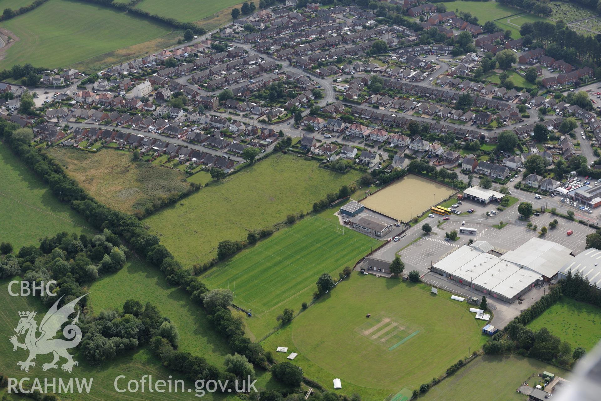 Bryn-yr-Eillon Tumulus (findspot of Mold gold cape) and the surrounding town of Mold. Oblique aerial photograph taken during the Royal Commission's programme of archaeological aerial reconnaissance by Toby Driver on 11th September 2015.