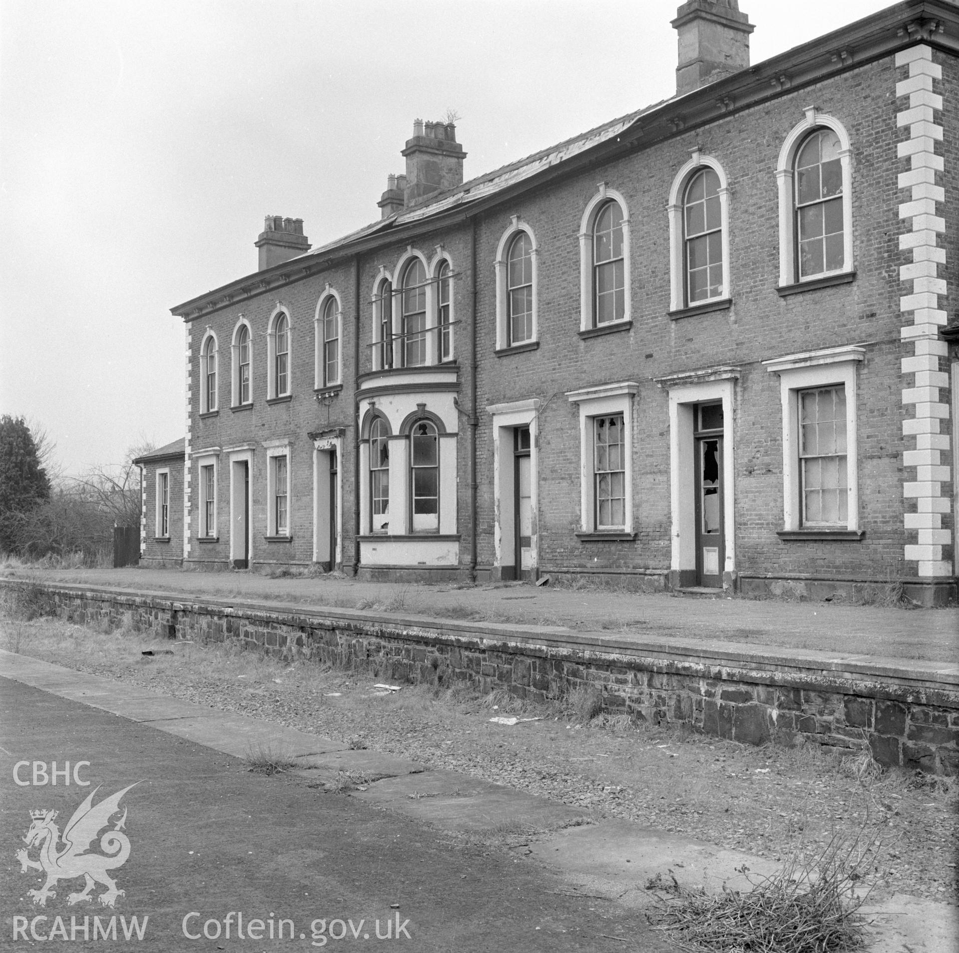 Digital copy of a black and white negative showing a view of the railtrack side elevation of Llanidloes Railway Station taken by Douglas Hague.