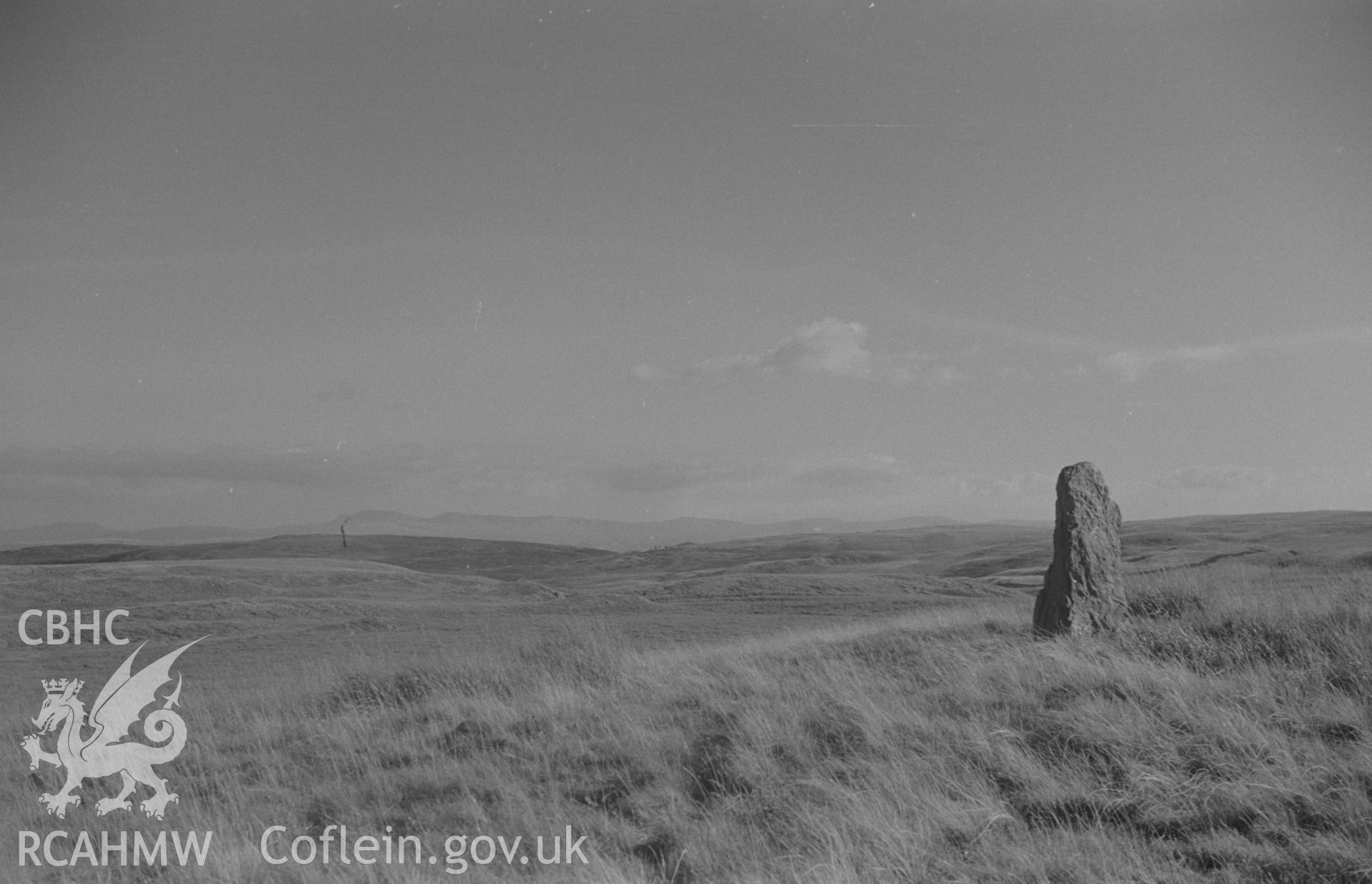 Digital copy of black & white negative showing standing stone near Carnau on Cefn Cnwcheithinog; the Black Mountains in the distance. Photographed by Arthur O. Chater in September 1966 looking south south east from Grid Reference SN 757 496.