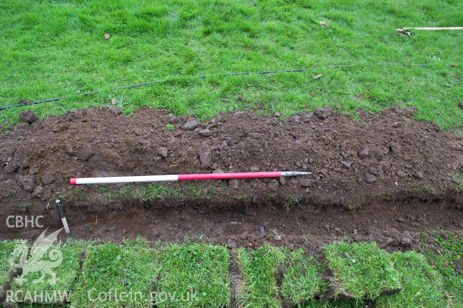 View from south of section through the topsoil, cut for service trench and fill of service trench. Photographed during archaeological watching brief of Plas Newydd, Ynys Mon, conducted by Gwynedd Archaeological Trust, 14th November 2017. Project no. 2542.