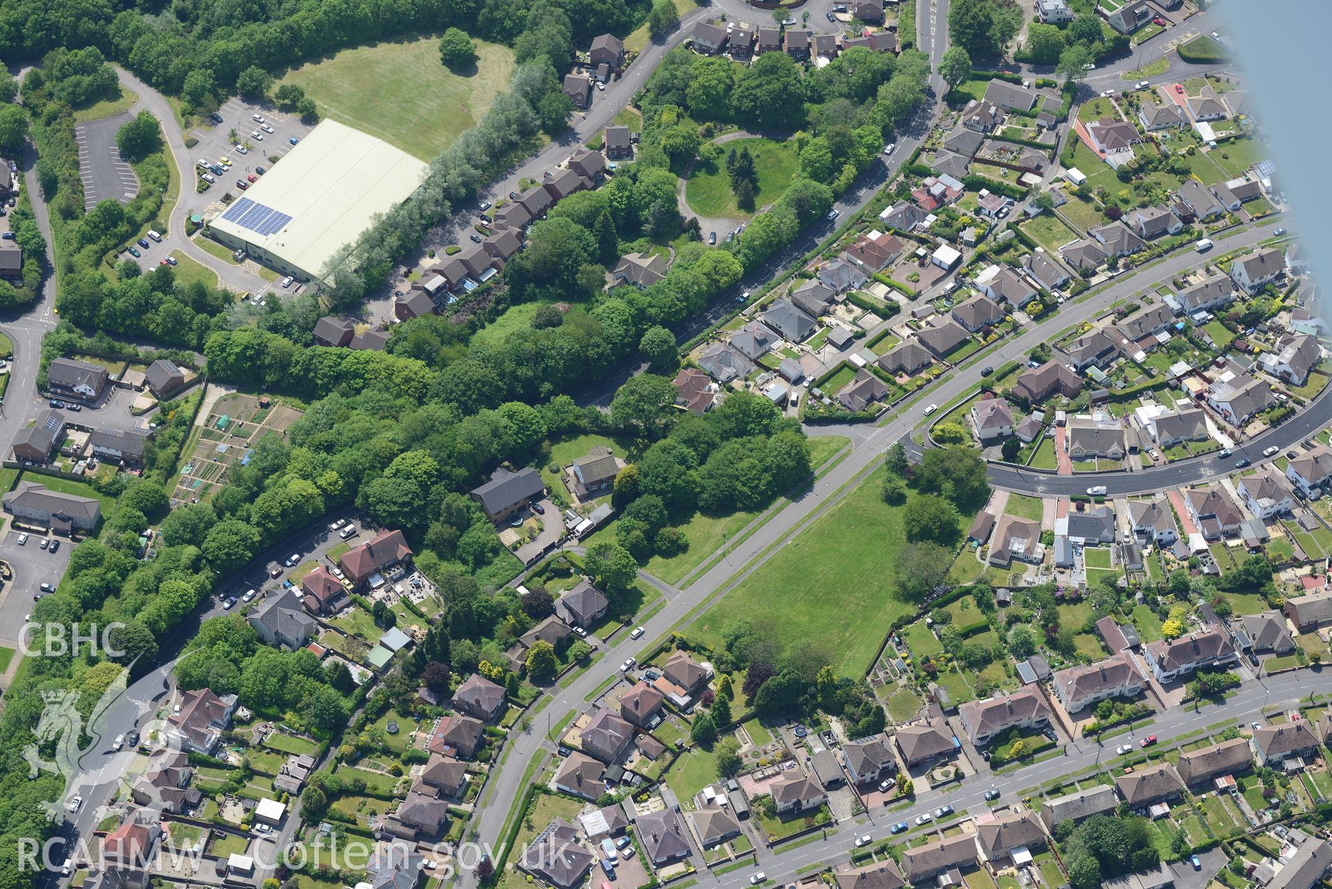 Pontllanfraith village, with Penllwyn Fawr enclosure at it's centre. Oblique aerial photograph taken during the Royal Commission's programme of archaeological aerial reconnaissance by Toby Driver on 11th June 2015.