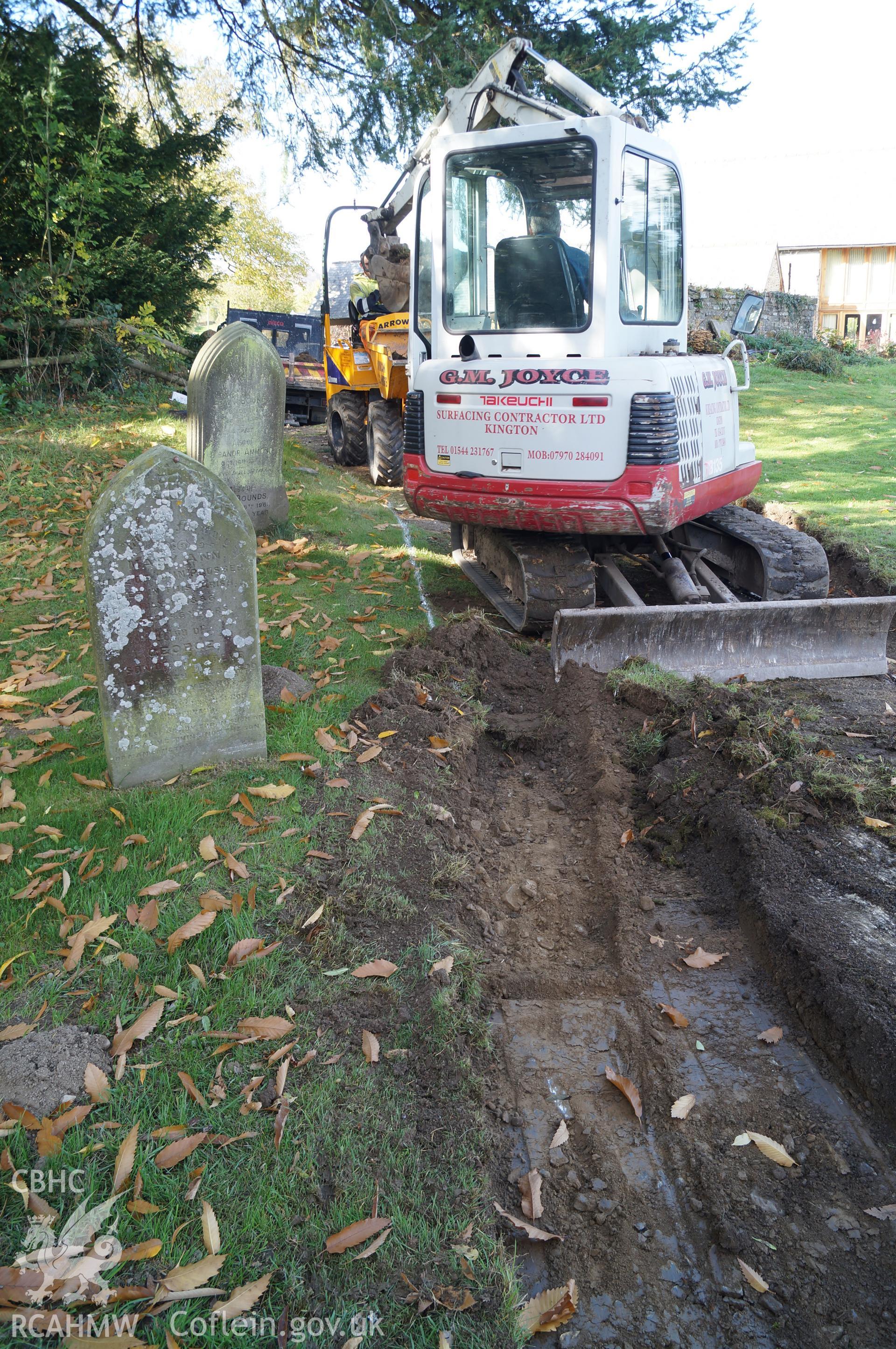 'Looking west northwest at excavated Trench B, on southwestern side of path, showing apparent upper fill of grave, possibly part of family associated with adjacent gravestone.' Photograph & description by Jenny Hall & Paul Sambrook of Trysor, 16/10/2017.