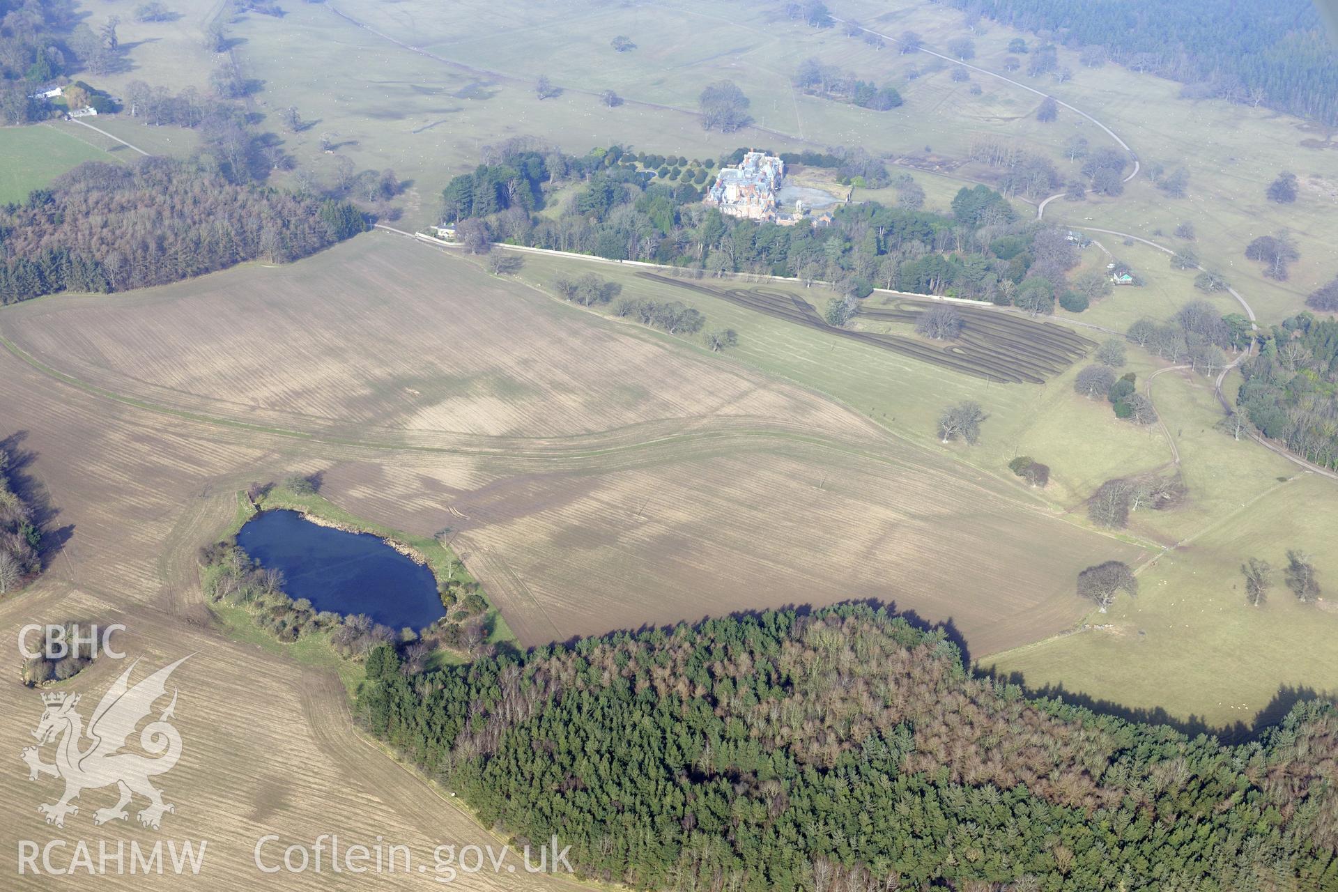 Kinmel Park, surrounded by its gardens, with the formal Venetian gardens immediately left of the house. Oblique aerial photograph taken during the Royal Commission?s programme of archaeological aerial reconnaissance by Toby Driver on 28th February 2013.