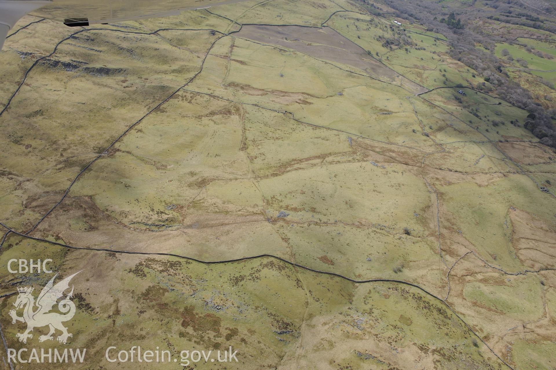 Ffridd Fedw round hut, enclosure, ancient field and kerb cairn, and Tyddyn Sion Wyn ring cairn, Talsarnau, north east of Harlech. Oblique aerial photograph taken during the Royal Commission?s programme of archaeological aerial reconnaissance by Toby Driver on 1st May 2013.