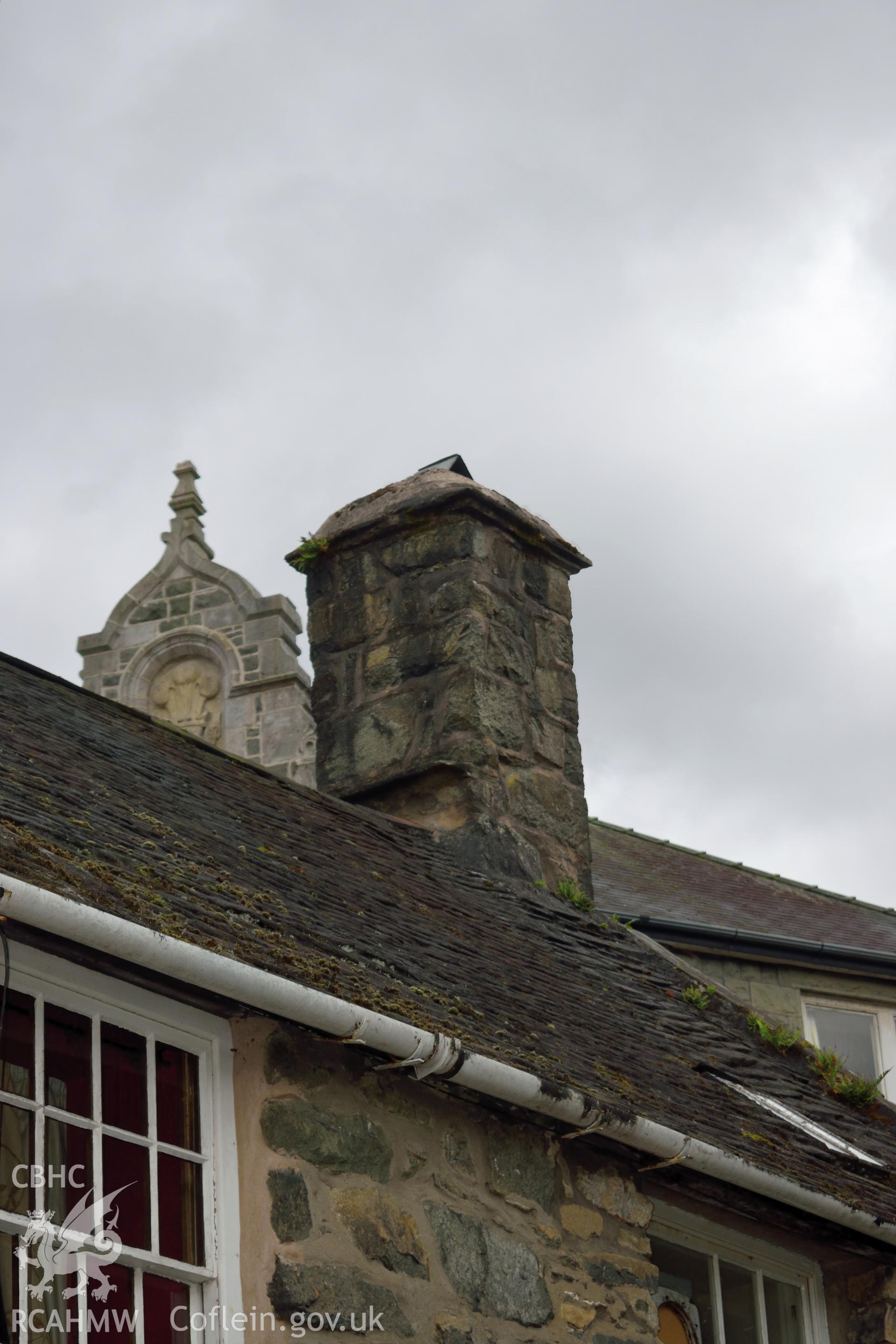 Colour photograph showing view looking south west at the gable end chimney of Y Sospan, Llys Owain, Dolgellau. Photographed by I. P. Brookes of Engineering Archaeological Services, June 2019.