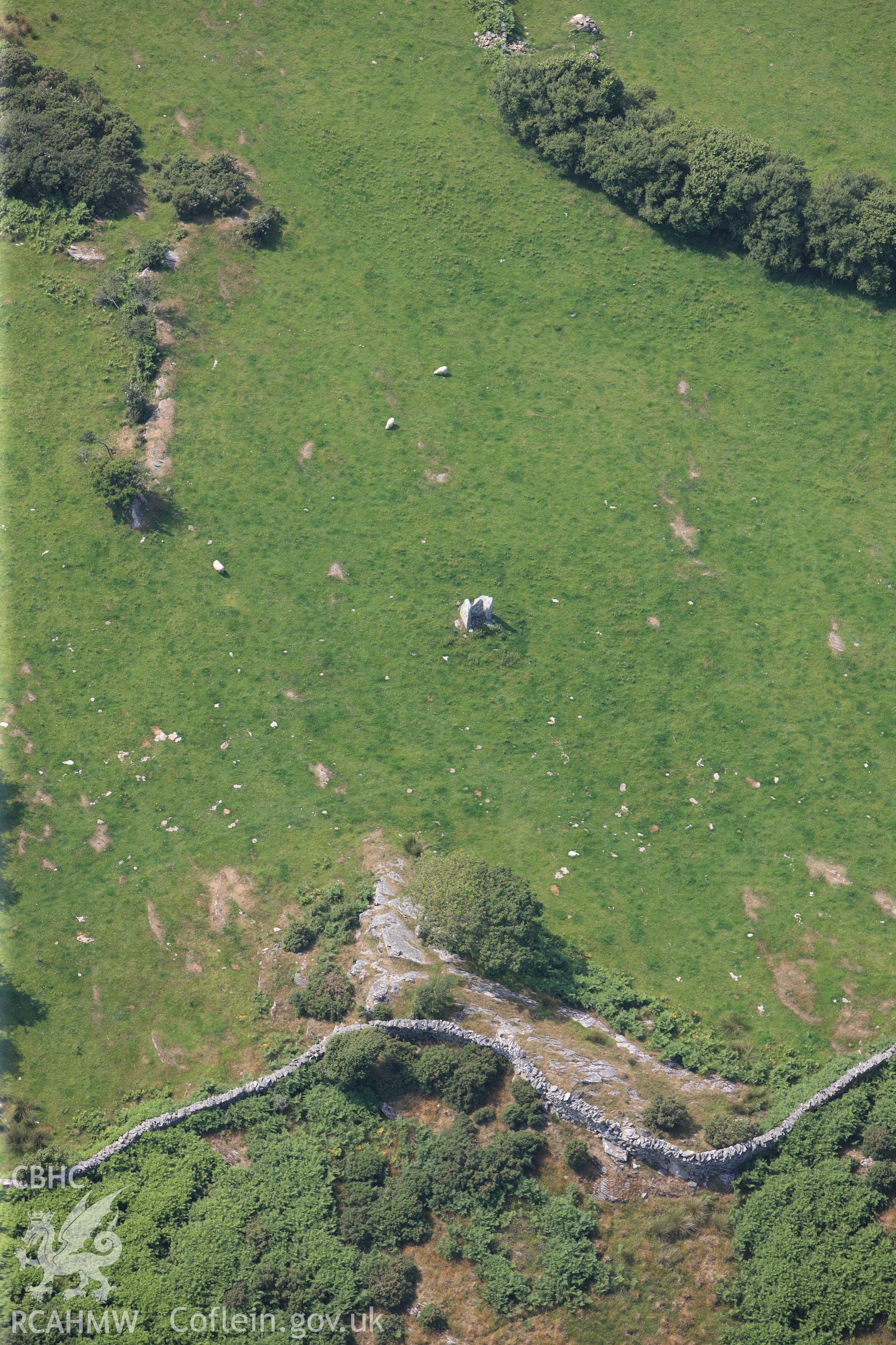 Cist Cerrig burial chamber, cup-marked outcrop and rock exposures. Oblique aerial photograph taken during the Royal Commission?s programme of archaeological aerial reconnaissance by Toby Driver on 12th July 2013.